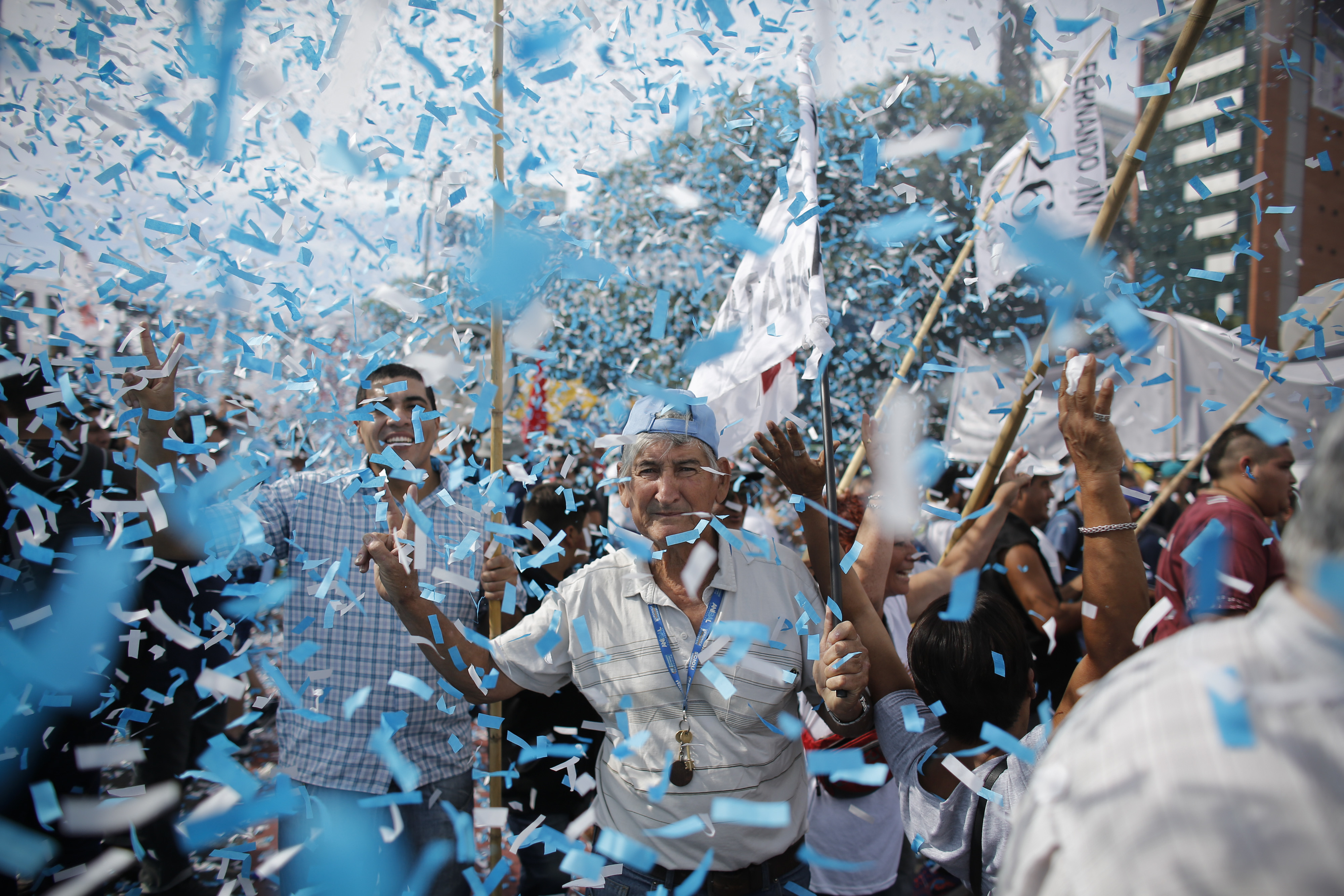 Confetti representing colors of the Argentine flag rain on demonstrators during a labor march in Buenos Aires, Argentina, Tuesday, March 7, 2017. Argentina's most powerful unions brought tens of thousands of people into the capital's streets to protest government job cuts, the lifting of restrictions on imports and other policies of President Mauricio Macri. (AP Photo/Victor R. Caivano)