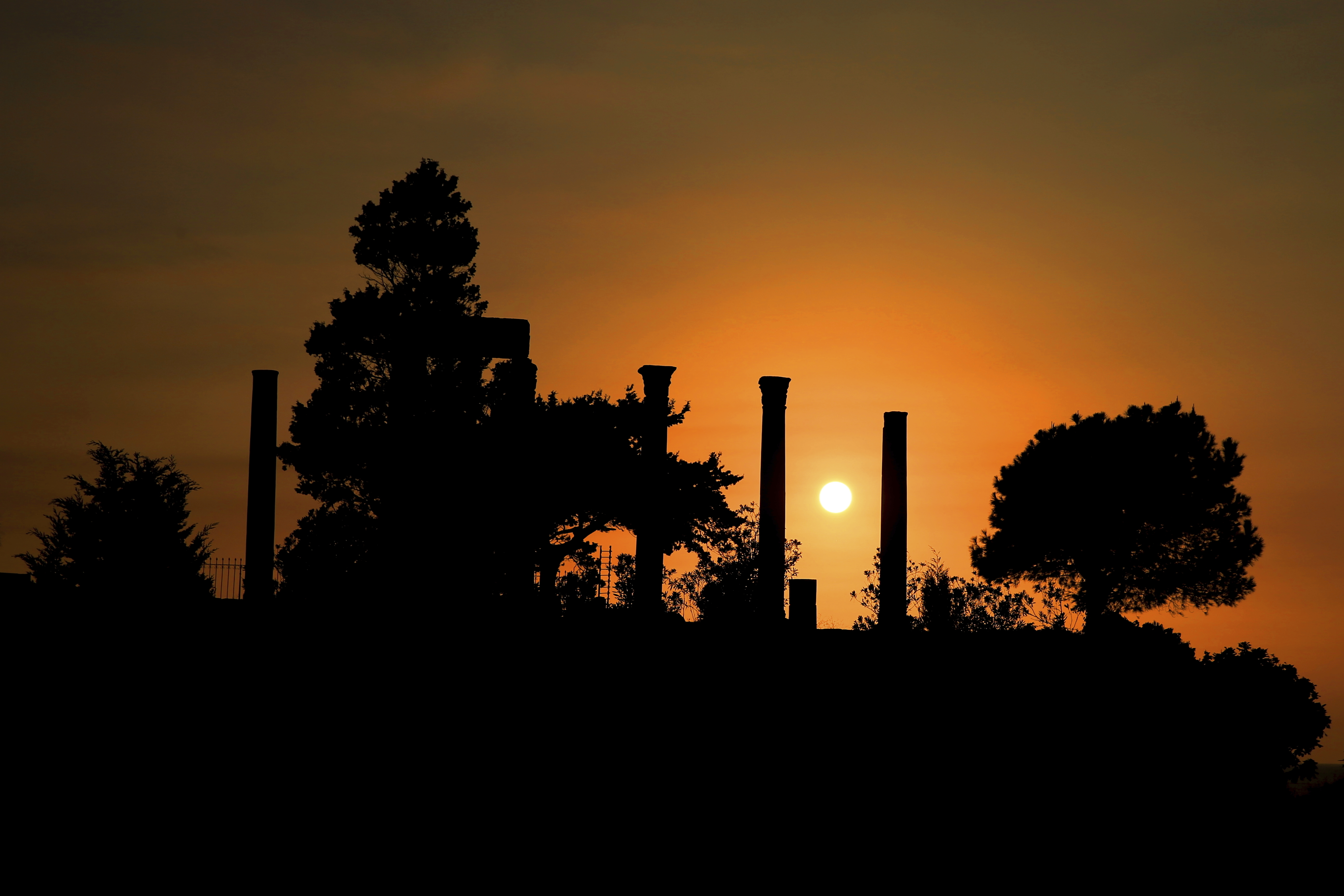 The sun sets behind the ruins of the ancient port city of Byblos, north of Beirut, Lebanon, Saturday, Oct. 8, 2016. (AP Photo/Hassan Ammar)