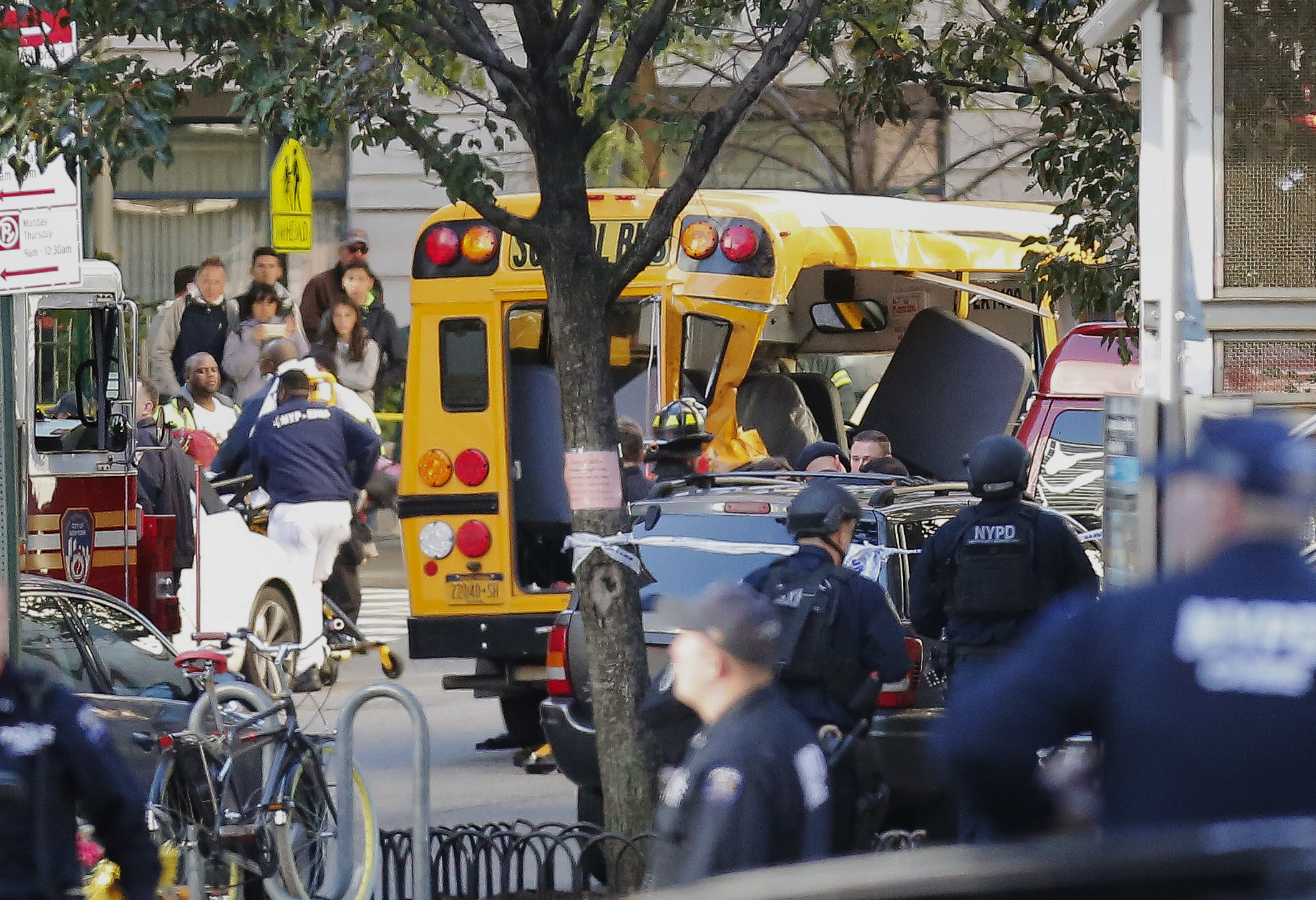 Authorities respond near a damaged school bus Tuesday, Oct. 31, 2017, in New York. A motorist drove onto a busy bicycle path near the World Trade Center memorial and struck several people on Tuesday police and witnesses said. (AP Photo/Bebeto Matthews)