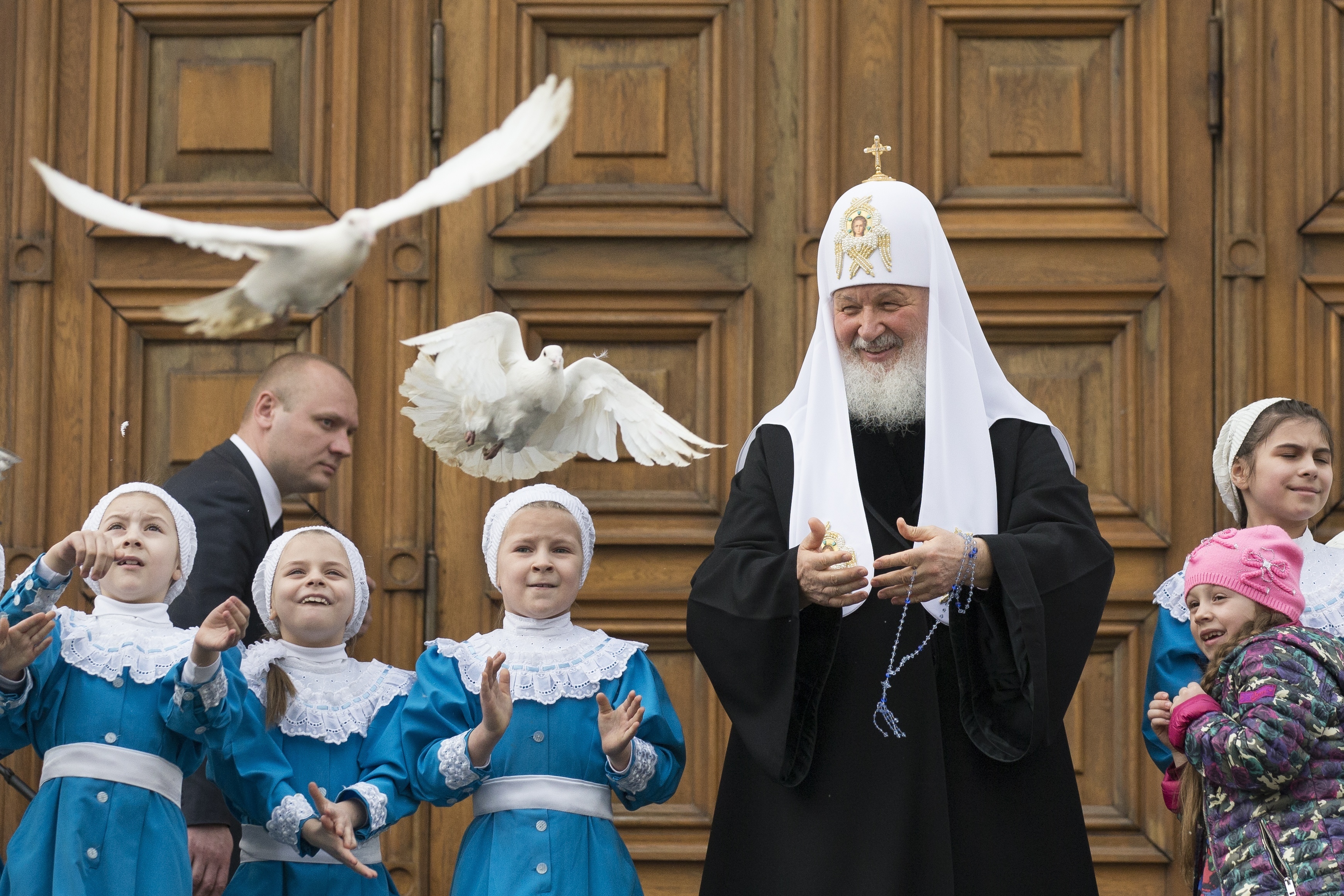 Russian Orthodox Church Patriarch Kirill, center, releases birds at Annunciation Cathedral in the Moscow's Kremlin in Moscow, Russia, Friday, April 7, 2017, to mark the Russian Orthodox holiday of the Annunciation. (AP Photo/Alexander Zemlianichenko)