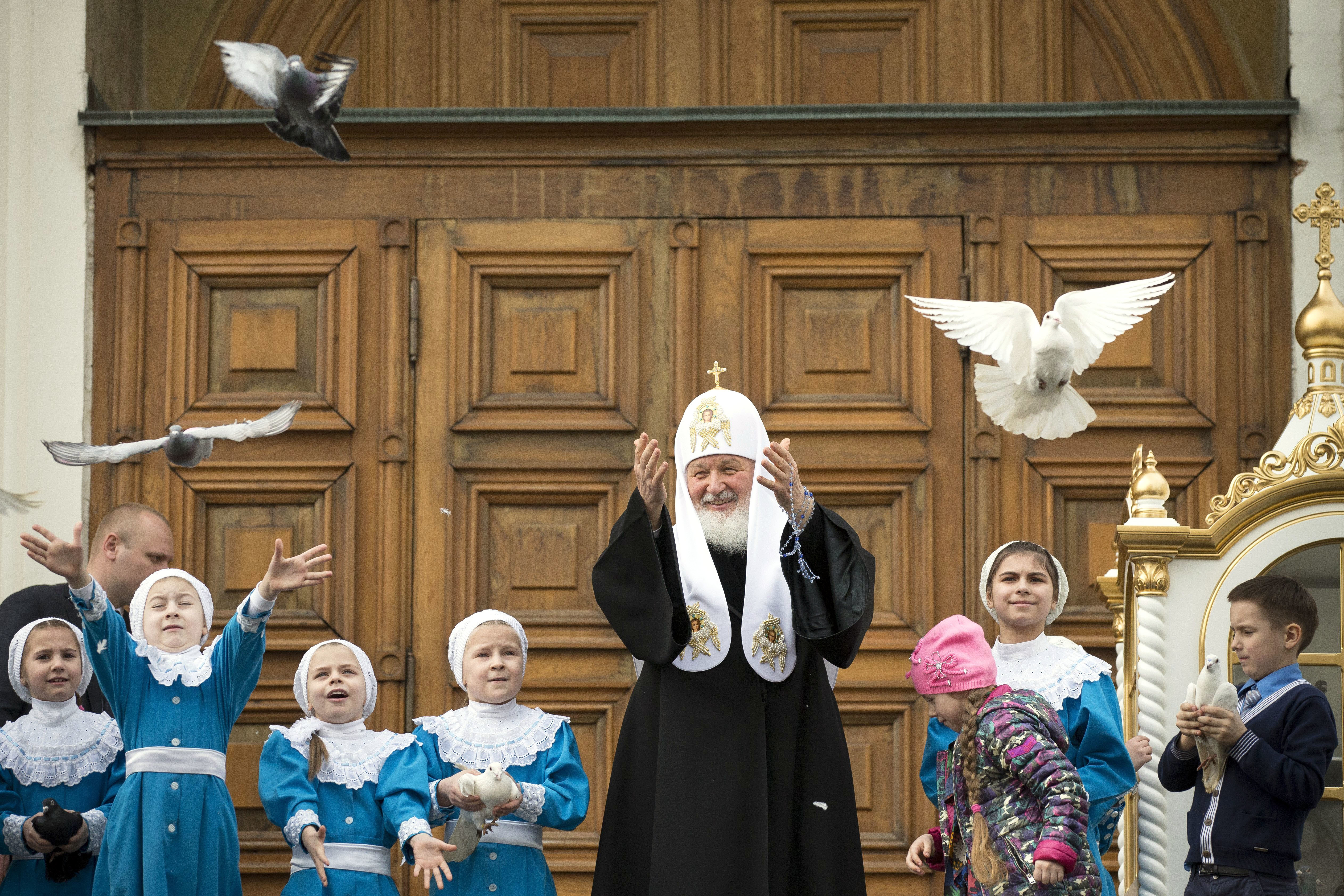 Russian Orthodox Church Patriarch Kirill, center, releases birds at Annunciation Cathedral in the Moscow's Kremlin in Moscow, Russia, Friday, April 7, 2017, to mark the Russian Orthodox holiday of the Annunciation. (AP Photo/Alexander Zemlianichenko)
