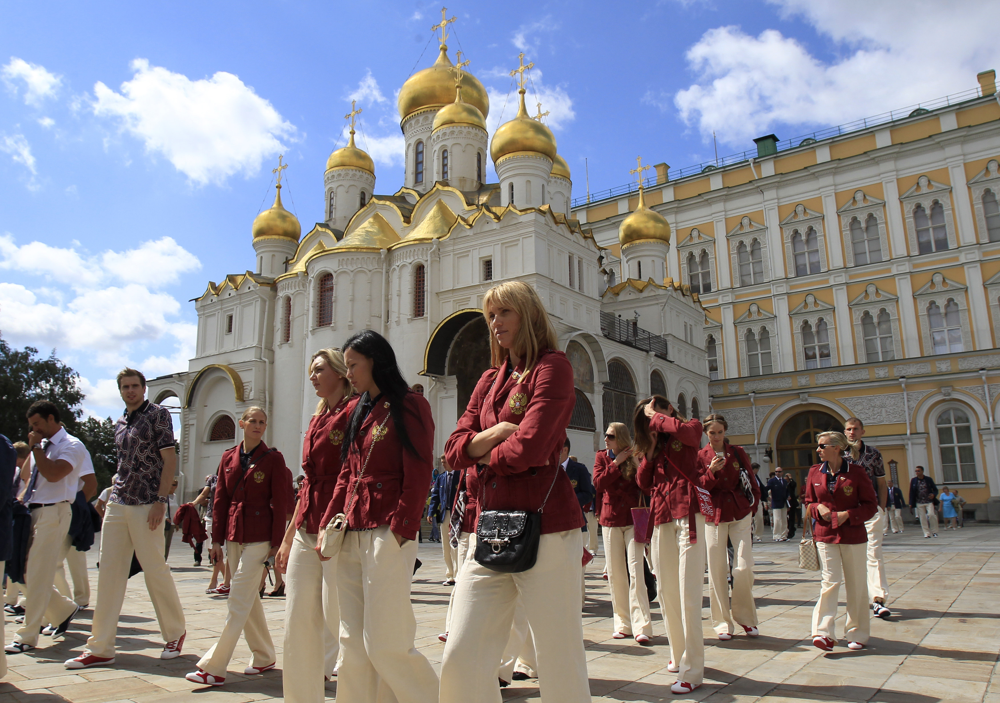 Members of the Russian national Olympic team walk after a meeting with Russian President Vladimir Putin before their departure for the 2012 London Olympic Games at the Kremlin in Moscow, Saturday, July 21, 2012. In the background is the Annunciation Cathedral and the Grand Kremlin Palace. (AP Photo/Sergei Karpukhin, Pool)