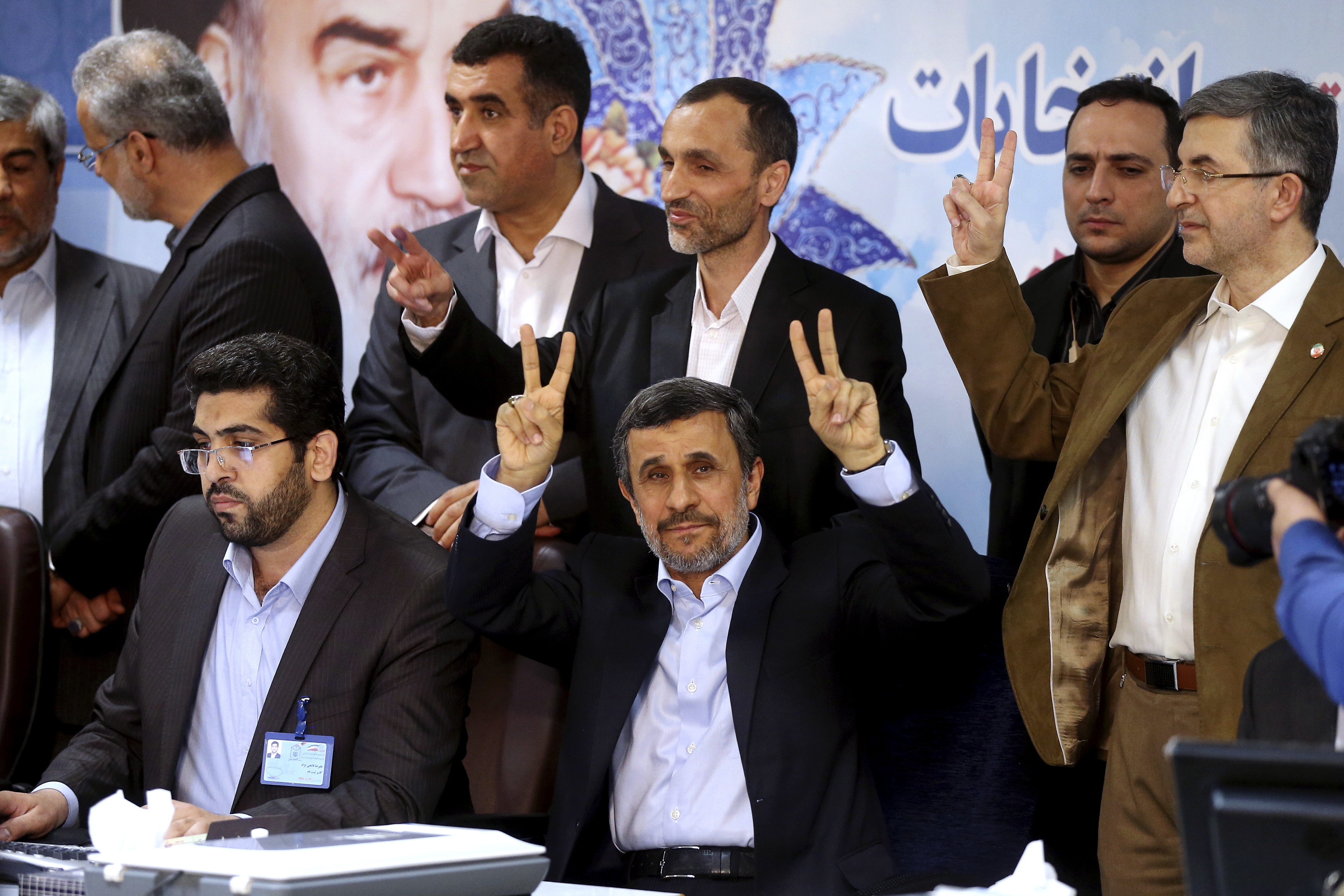 Former Iranian President Mahmoud Ahmadinejad, seated center, flashes the victory sign as he is registering candidacy for the upcoming presidential elections at the Interior Ministry in Tehran, Iran, Wednesday, April 12, 2017. Ahmadinejad on Wednesday unexpectedly filed to run in the country's May presidential election, contradicting a recommendation from the supreme leader to stay out of the race. (AP Photo/Ebrahim Noroozi)