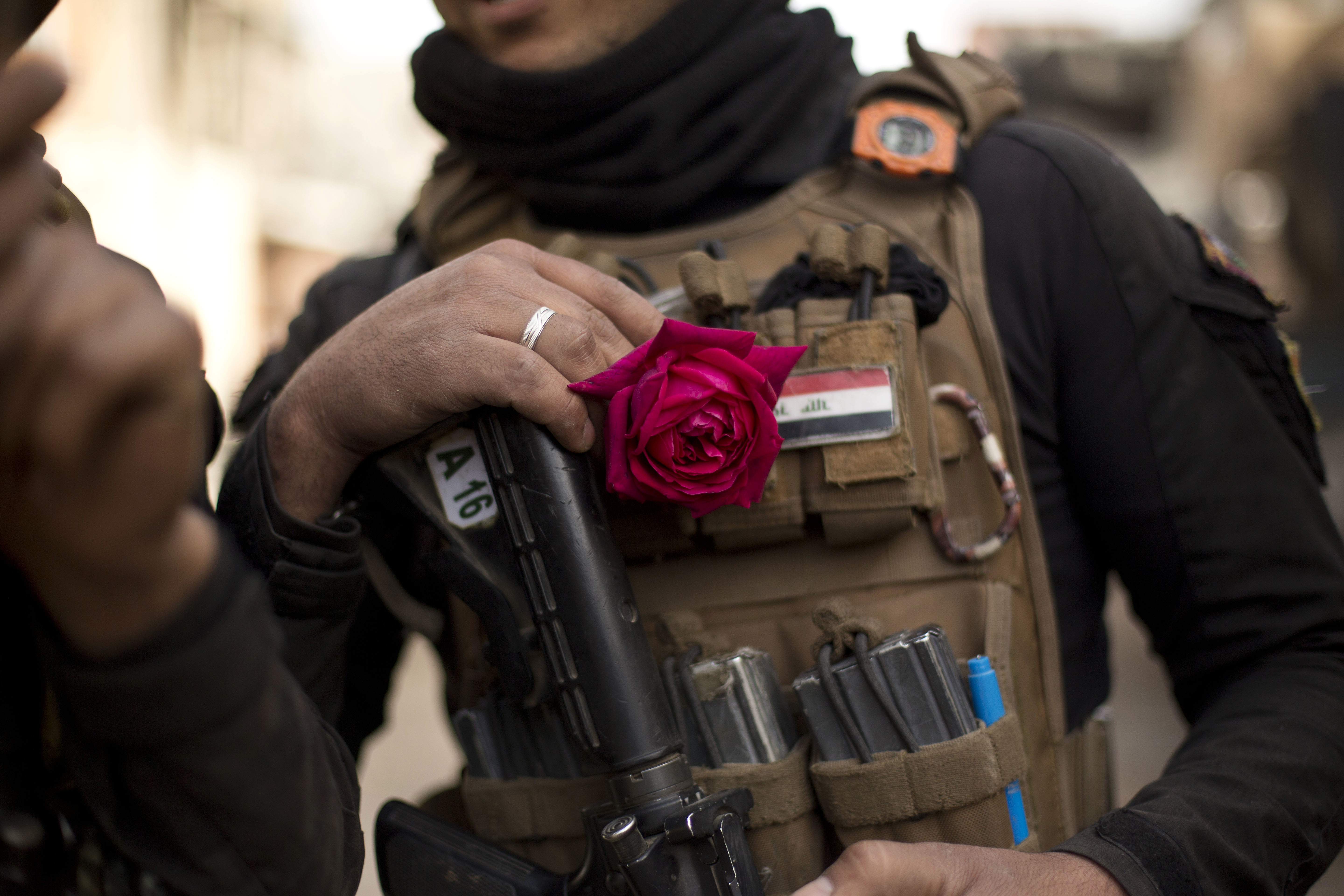 An Iraqi special forces soldier wears a rose in his body armor as troops move from the Yarmouk neighborhood to take another district from Islamic State militant control in Mosul, Iraq, Wednesday, April 12, 2017. (AP Photo/Maya Alleruzzo)