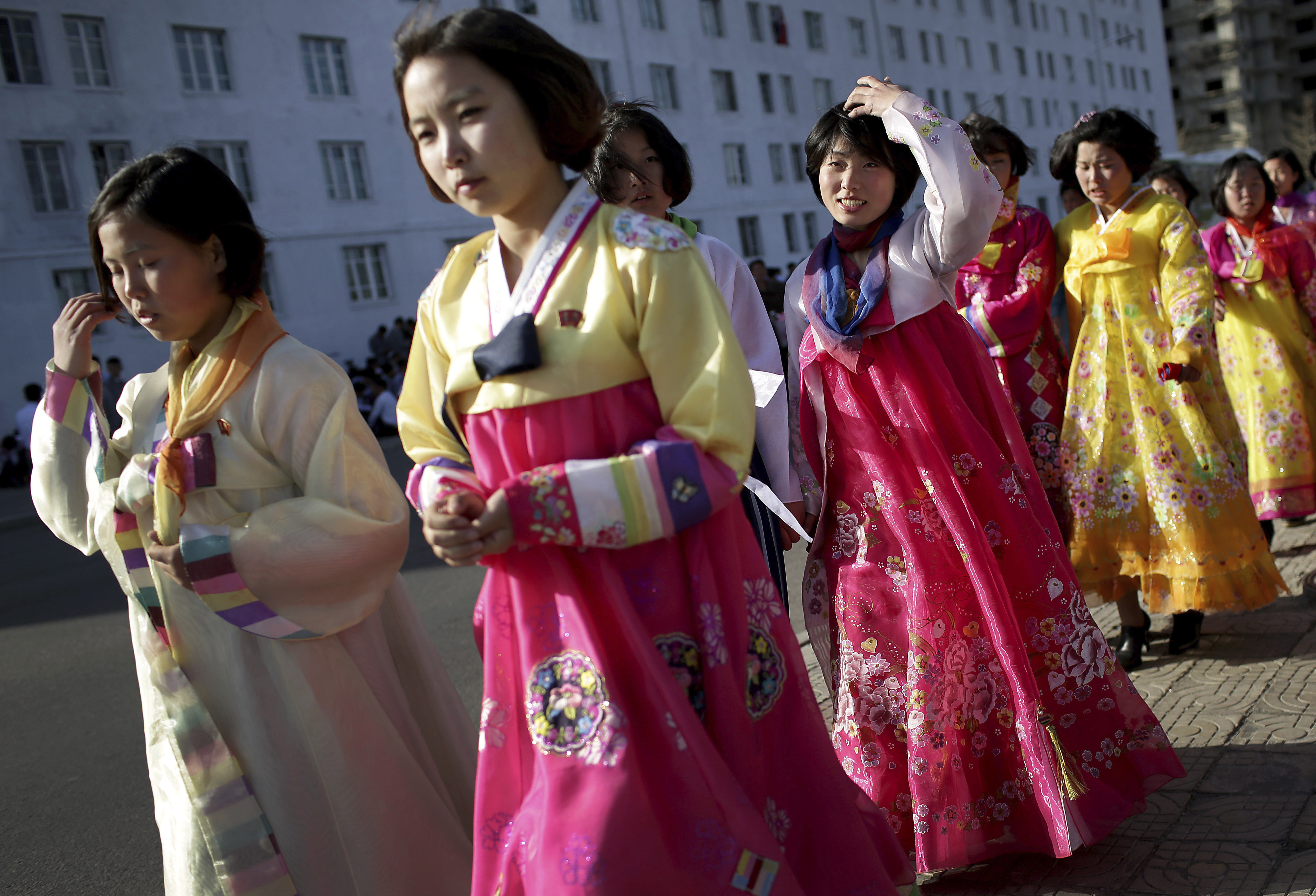 North Korean girls wearing traditional dresses walk along the street in front of Kim Il Sung Square Wednesday, April 12, 2017, in Pyongyang, North Korea. North Korea will mark the 105th anniversary of the birth of the late leader Kim Il Sung on April 15. (AP Photo/Wong Maye-E)