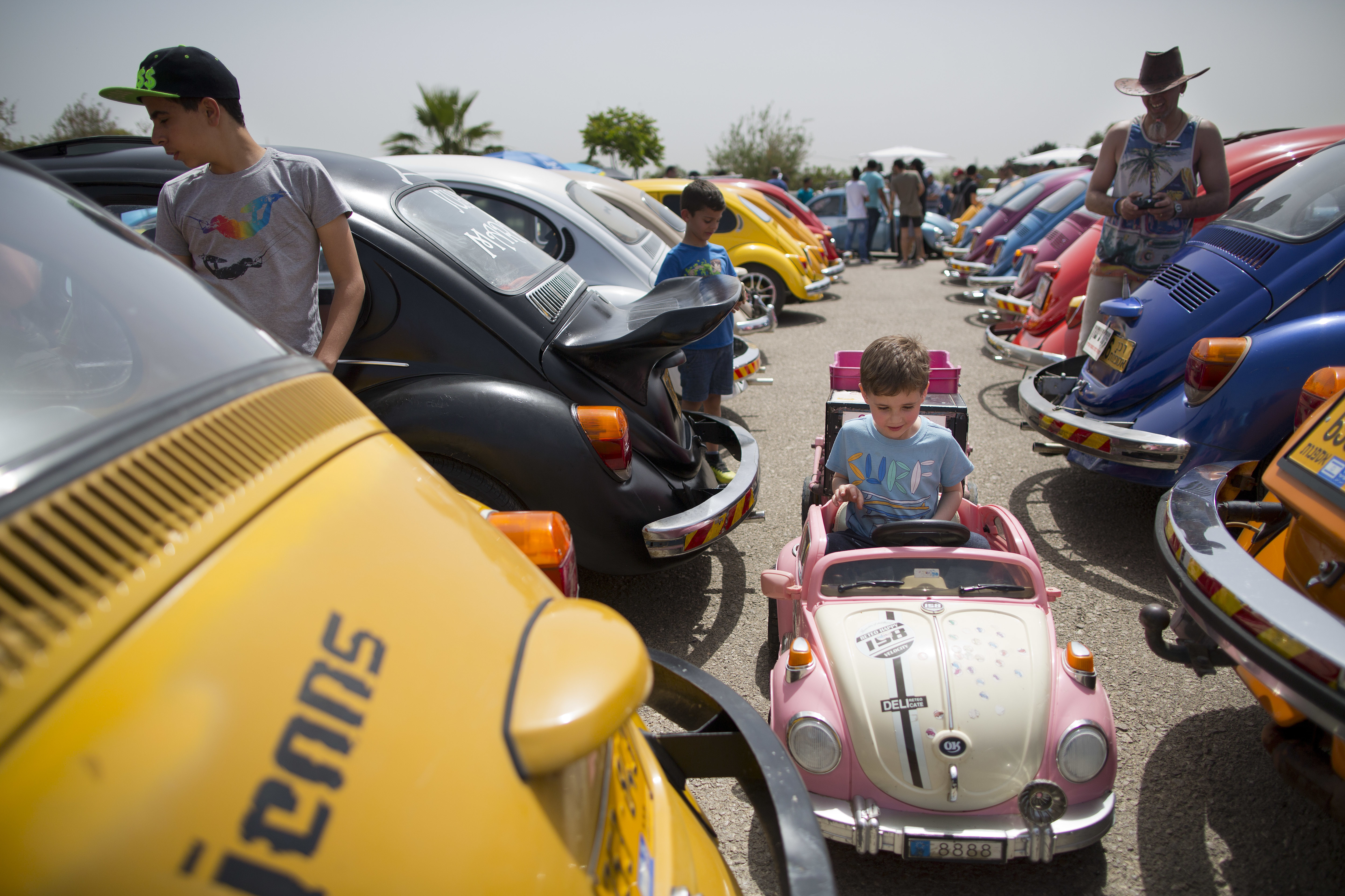 A young kid sits in a small Volkswagen Beetles as others displayed during the annual gathering of the 