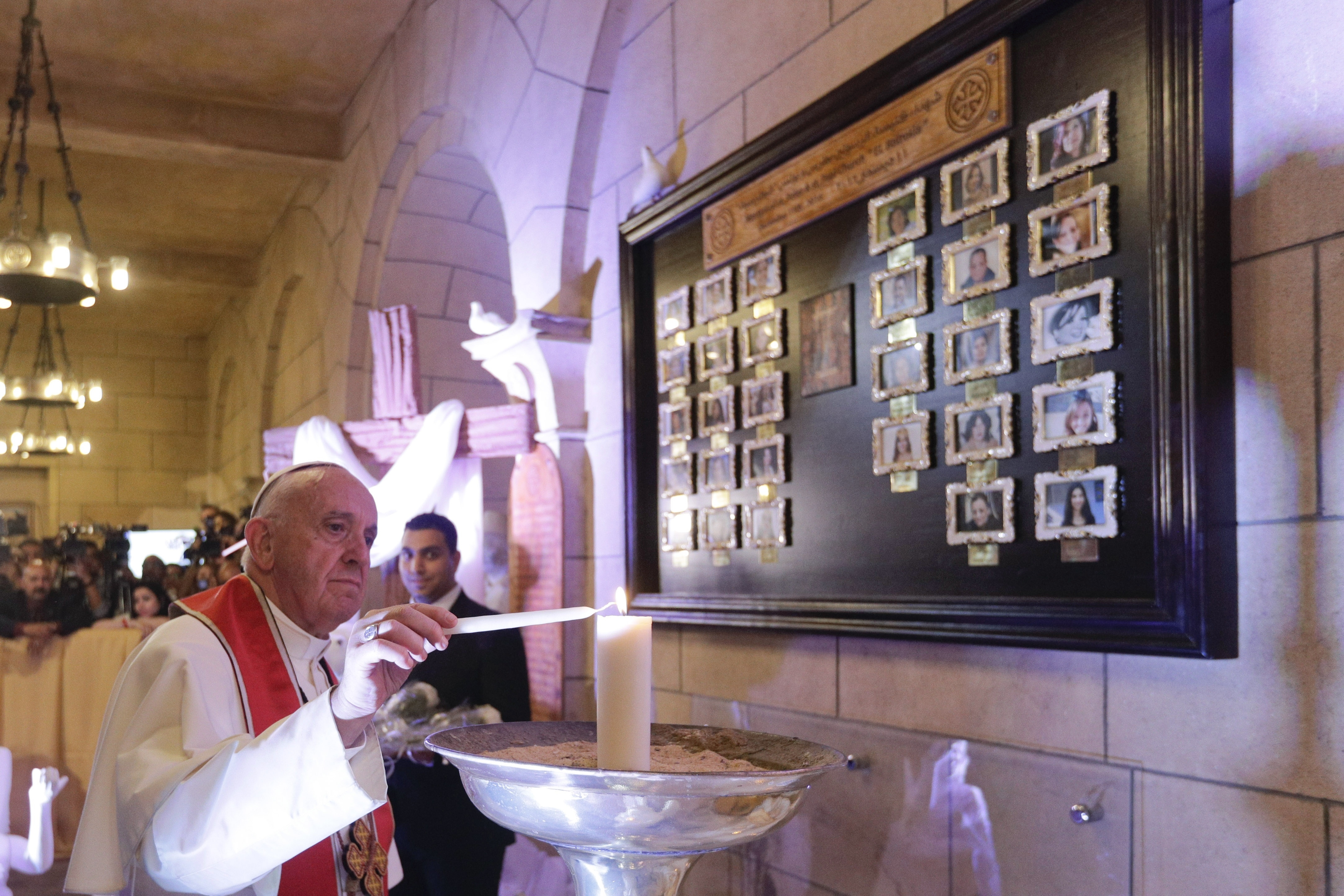 Pope Francis lights a candle at Cairo's St. Mark's Cathedral, Friday, April 28, 2017. Francis is in Egypt for a two-day trip aimed at presenting a united Christian-Muslim front that repudiates violence committed in God's name. (AP Photo/Gregorio Borgia)