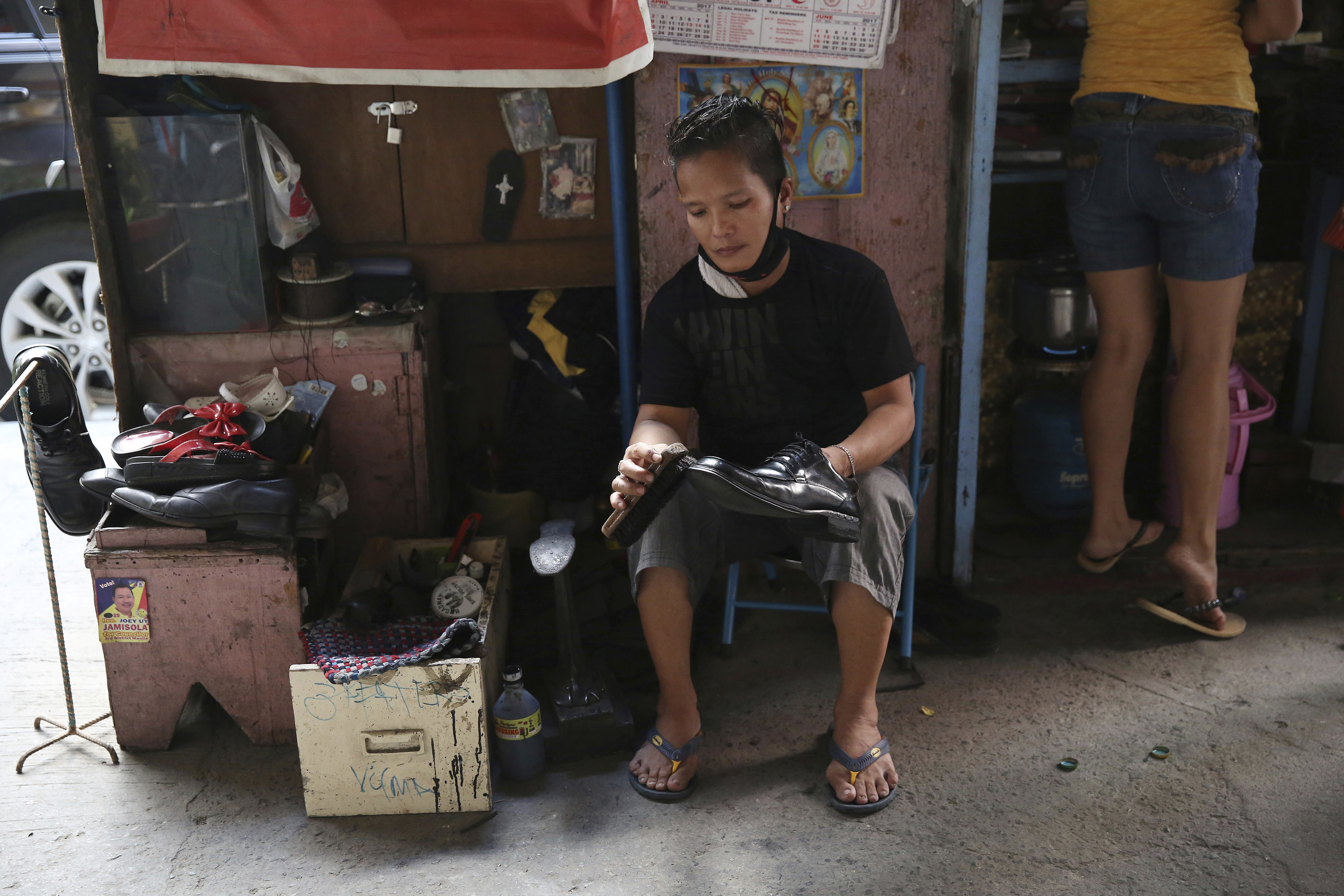 Vilma Magpayo cleans shoes for P20 (about US40 cents) per pair at her makeshift stall in downtown Manila, Philippines Tuesday, May 16, 2017. Magpayo said she earns about 300 pesos (about US$6) a day from cleaning and repairing shoes. (AP Photo/Aaron Favila)