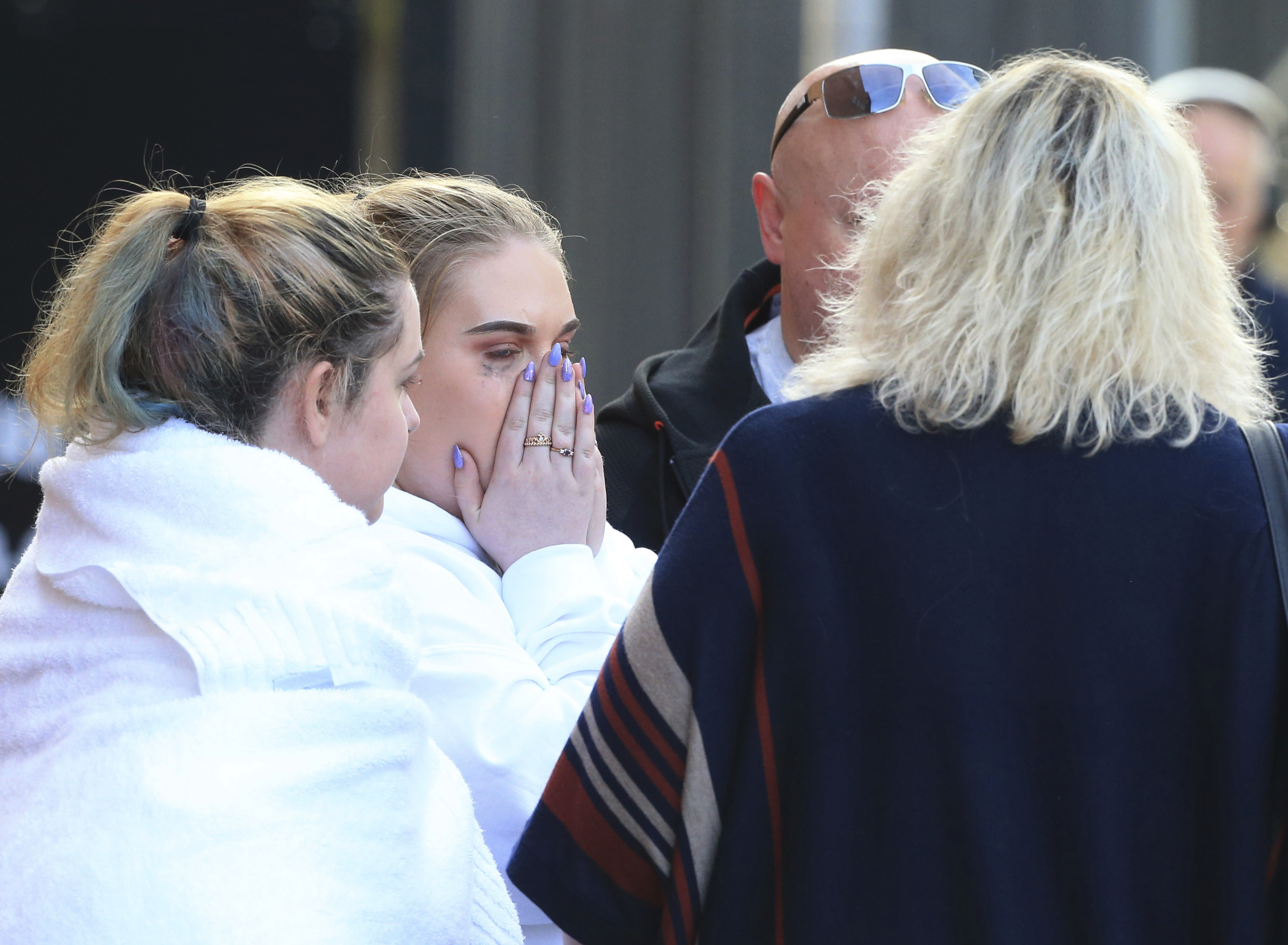 Fan leaves the Park Inn hotel in central Manchester, England, Tuesday, May 23, 2017. Over a dozen people were killed in an explosion following a Ariana Grande concert at the Manchester Arena late Monday evening. (AP Photo/Rui Vieira)