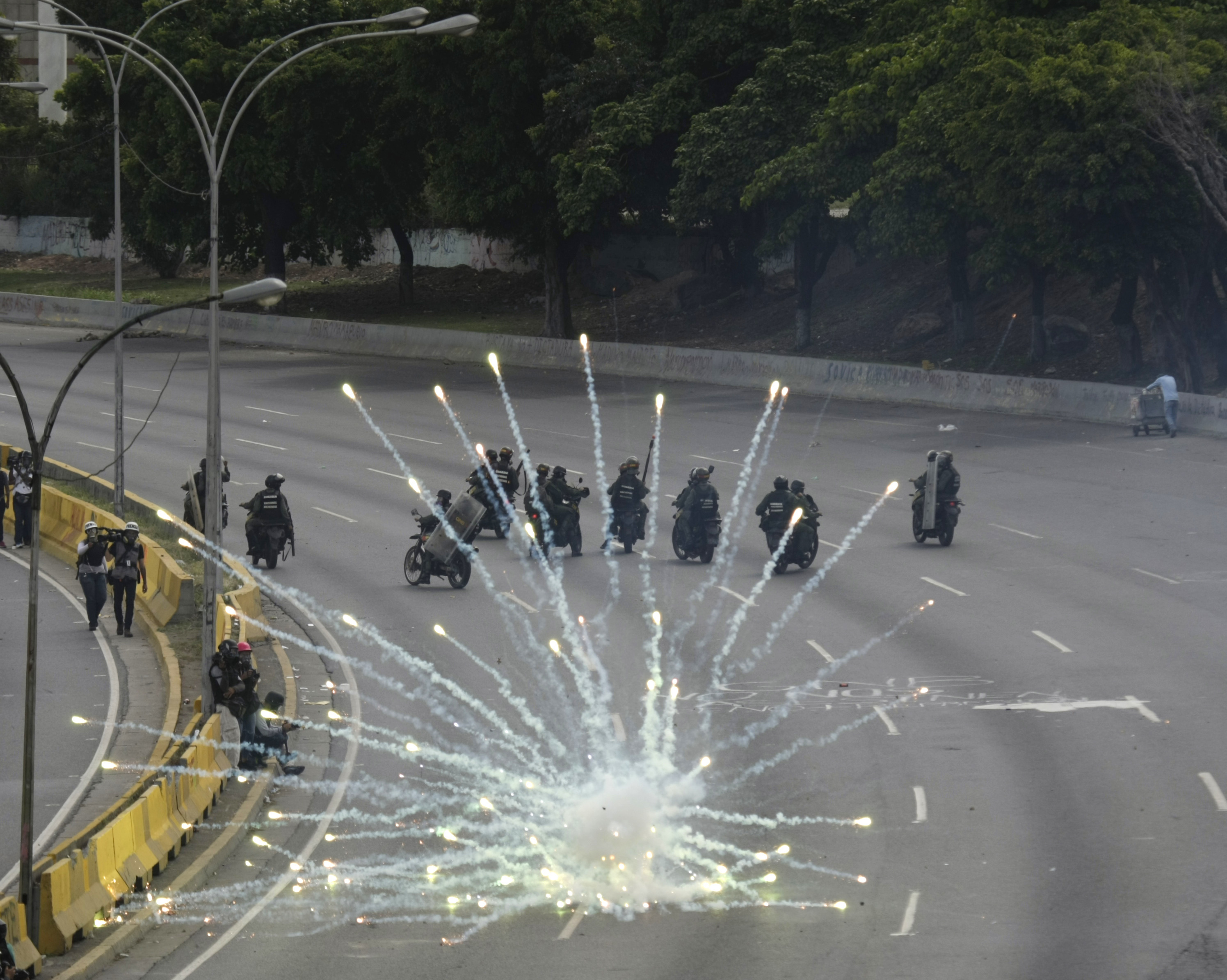 Fireworks launched by anti-government demonstrators explode next to government forces during clashes in Caracas, Venezuela, Wednesday, May 31, 2017. Protests have left dozens dead in the last two months as the opposition protests for immediate presidential elections and the liberation of political prisoners. (AP Photo/Fernando Llano)