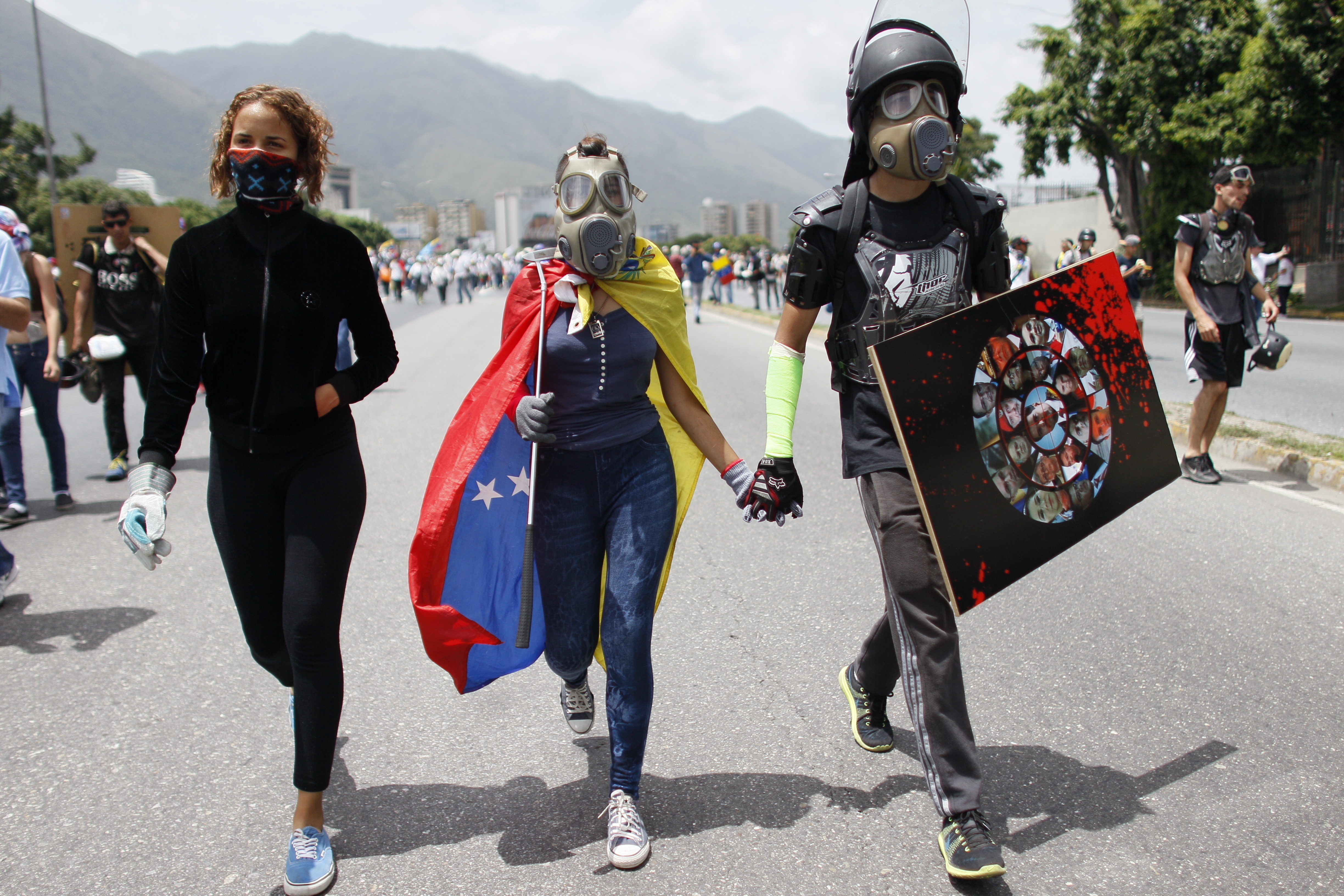Masked demonstrators walk carrying a golf club, center, and homemade shield as they join a march against the government of President Nicolas Maduro in Caracas, Venezuela, Wednesday, May 31, 2017. Protests have left dozens dead in the last two months as the opposition demands immediate presidential elections and the liberation of political prisoners. (AP Photo/Ariana Cubillos)