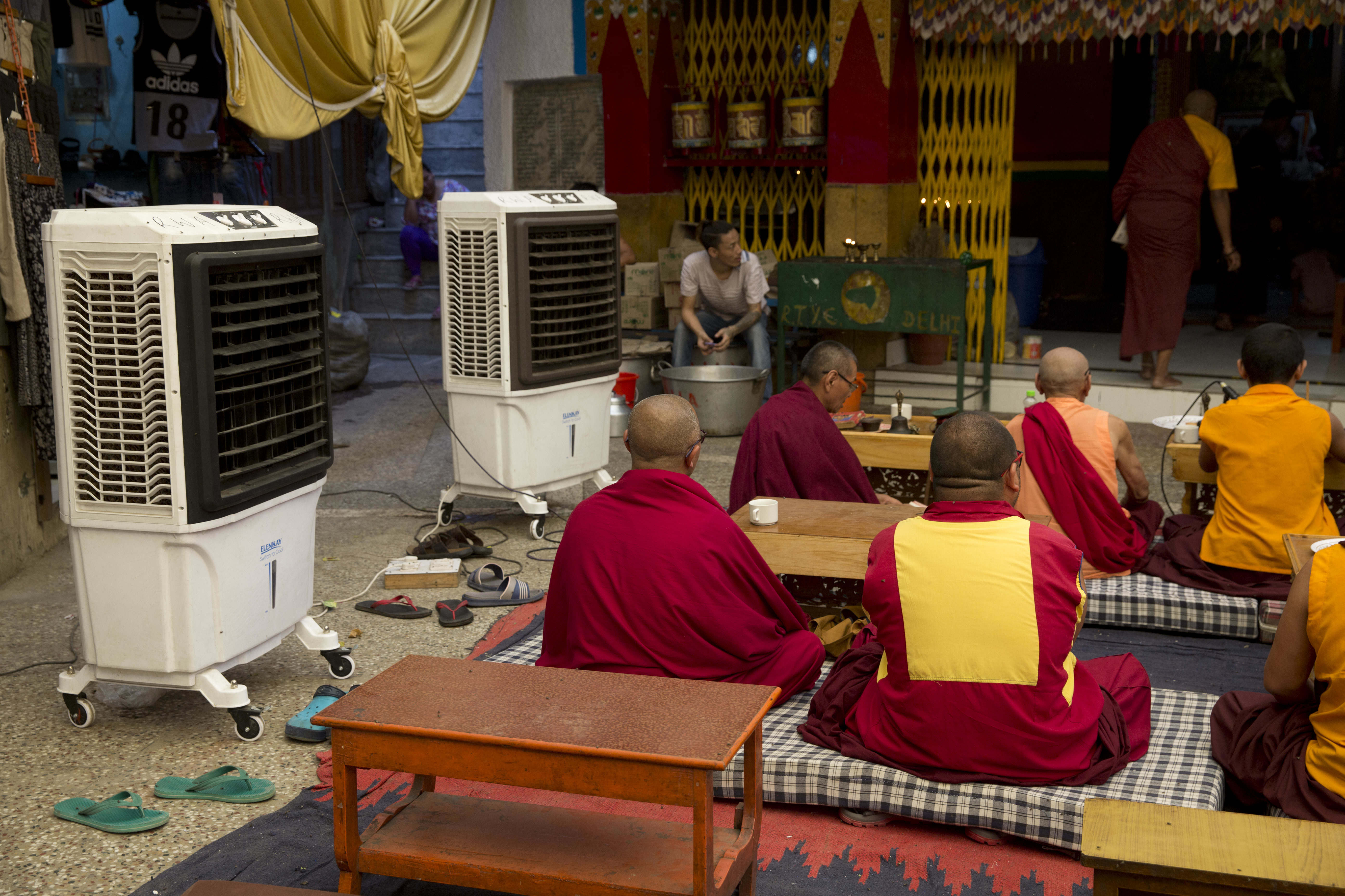 Exile Tibetan monks use air coolers to ward off heat while they pray in New Delhi, India, Monday, June 5, 2017. Most parts of northern India is reeling under intense heat wave conditions with the temperature crossing over 43 degrees Celsius (109.4 Fahrenheit).(AP Photo/Tsering Topgyal)