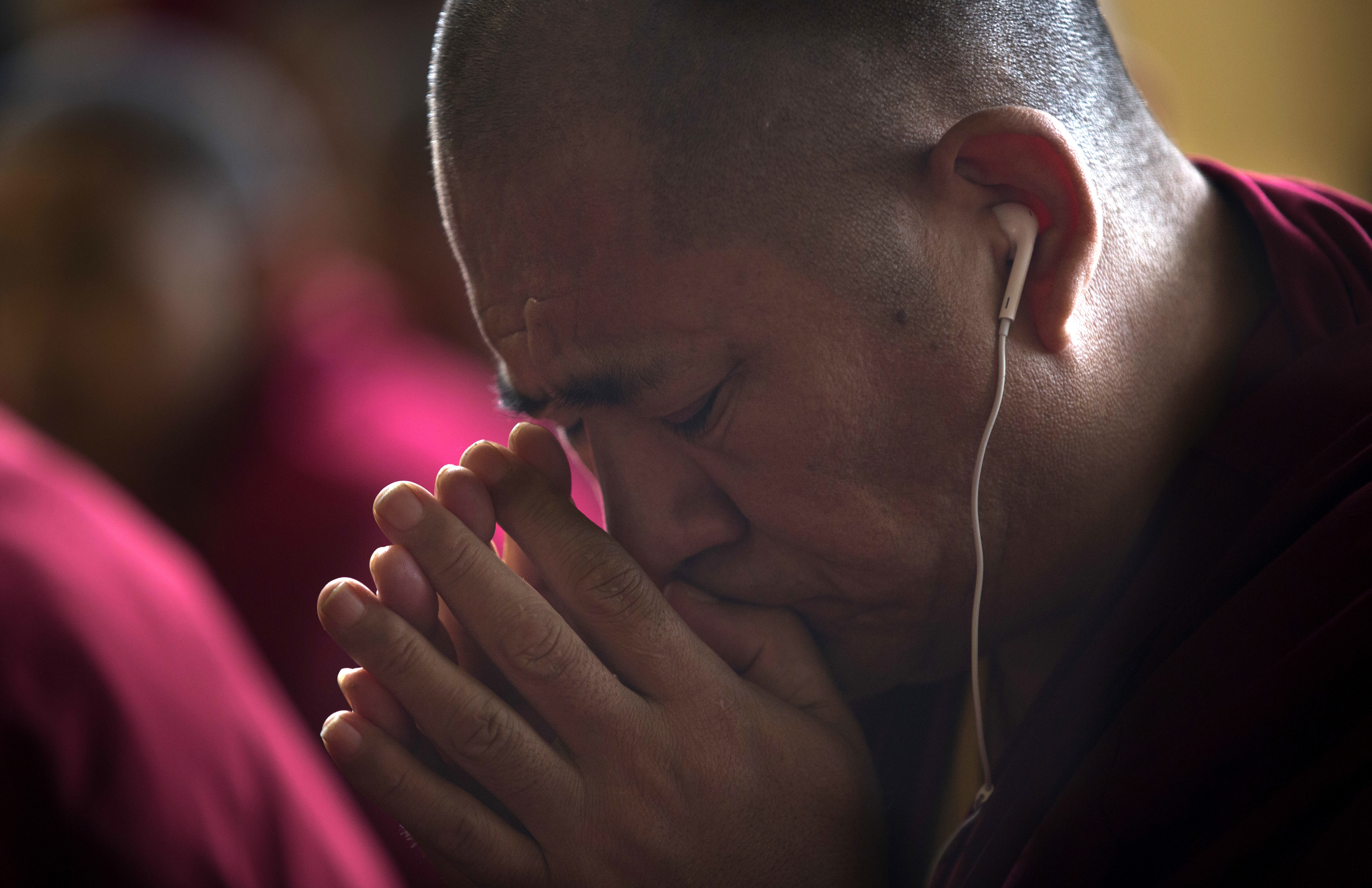 A Tibetan Buddhist monk prays as he listens to his spiritual leader the Dalai Lama during a religious talk at the Tsuglagkhang temple in Dharmsala, India, Wednesday, June 7, 2017. Each year the Tibetan leader talks to young Tibetans on Buddhist philosophy and selected texts. The three-day talk ended Wednesday. (AP Photo/Ashwini Bhatia)