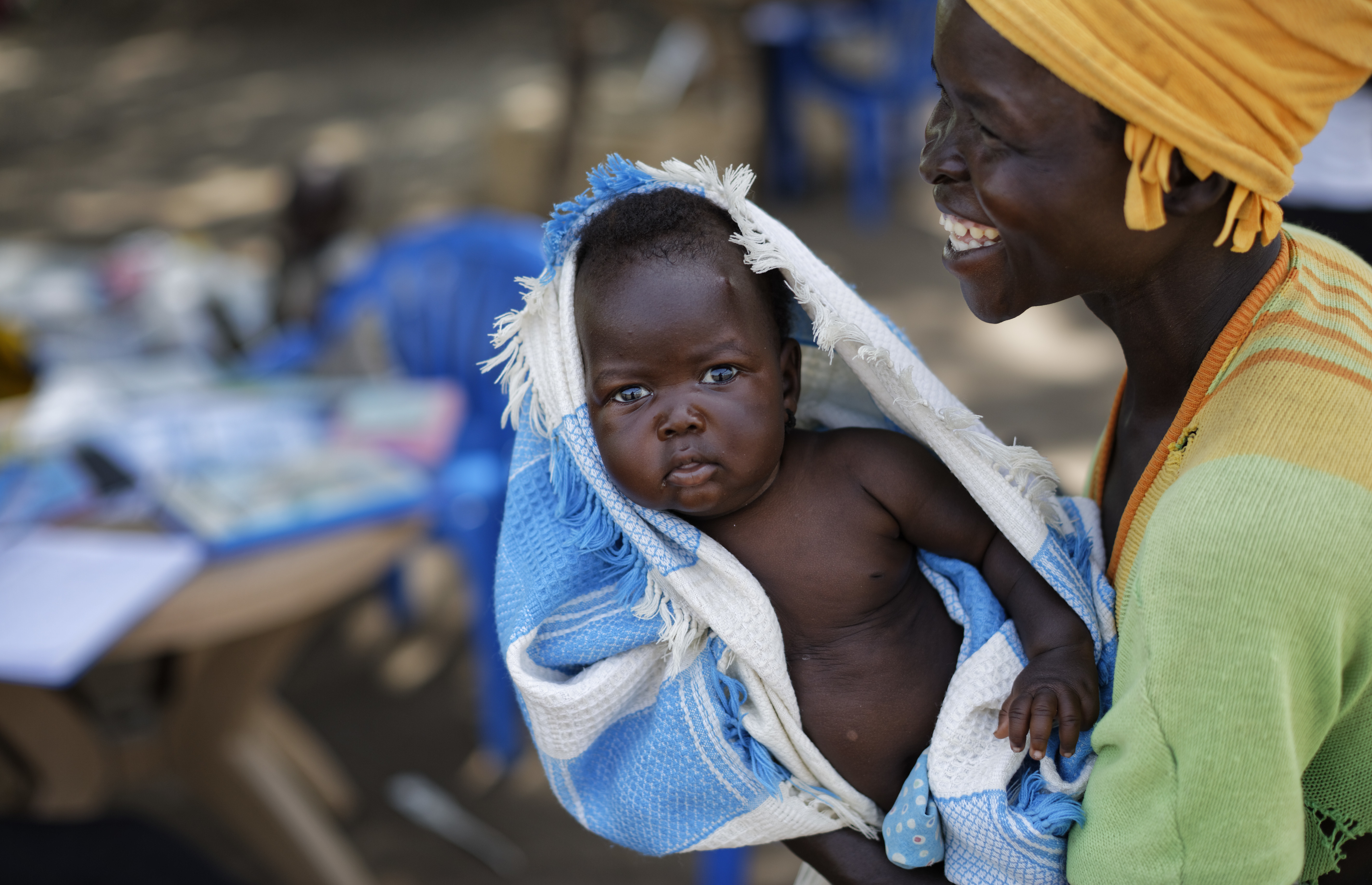 South Sudanese refugee Betty Sakala, from Central Equatoria state, laughs after being shown a photo of her daughter Mary, 2 months, as she waits to have Mary examined at a mobile health clinic run by the International Rescue Committee, in Bidi Bidi, Uganda, Monday, June 5, 2017. Bidi Bidi is a sprawling complex of mud-brick houses that is now the world's largest refugee settlement holding some of those who fled the civil war in South Sudan, which has killed tens of thousands and driven out more than 1.5 million people in the past three years, creating the world's largest refugee crisis. (AP Photo/Ben Curtis)