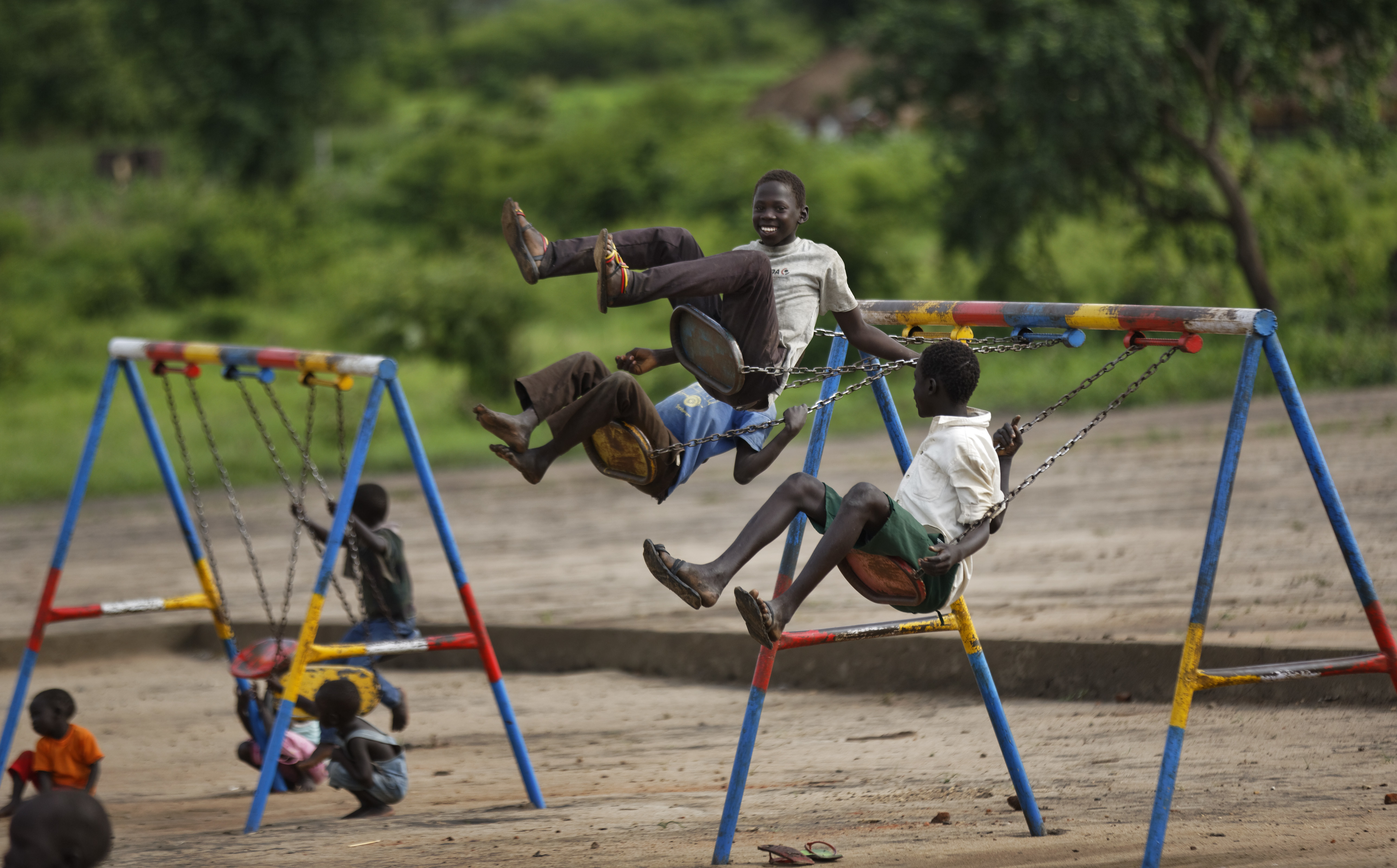 South Sudanese refugee children play on swings during morning break in the yard of the Ombechi nursery school, which has over 500 pupils and is supported by UNICEF and Save the Children, in Bidi Bidi, Uganda Wednesday, June 7, 2017. Bidi Bidi is a sprawling complex of mud-brick houses that is now the world's largest refugee settlement holding some of those who fled the civil war in South Sudan, which has killed tens of thousands and driven out more than 1.5 million people in the past three years, creating the world's largest refugee crisis. (AP Photo/Ben Curtis)