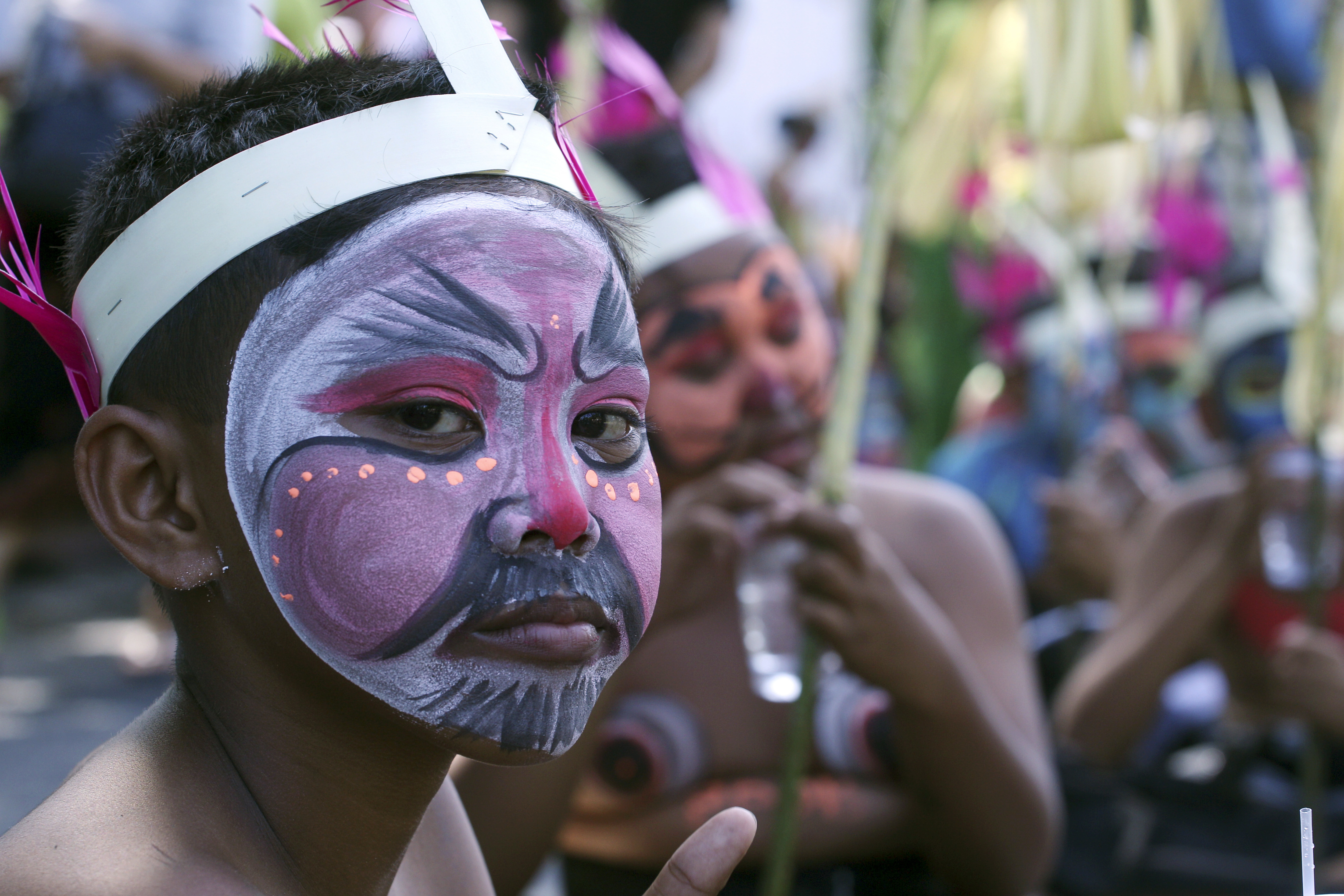 A boy with a panted face take part of the Bali Arts Festival parade in Bali, Indonesia, Saturday, June 10, 2017. A month-long annual festival started on Saturday. (AP Photo/Firdia Lisnawati)
