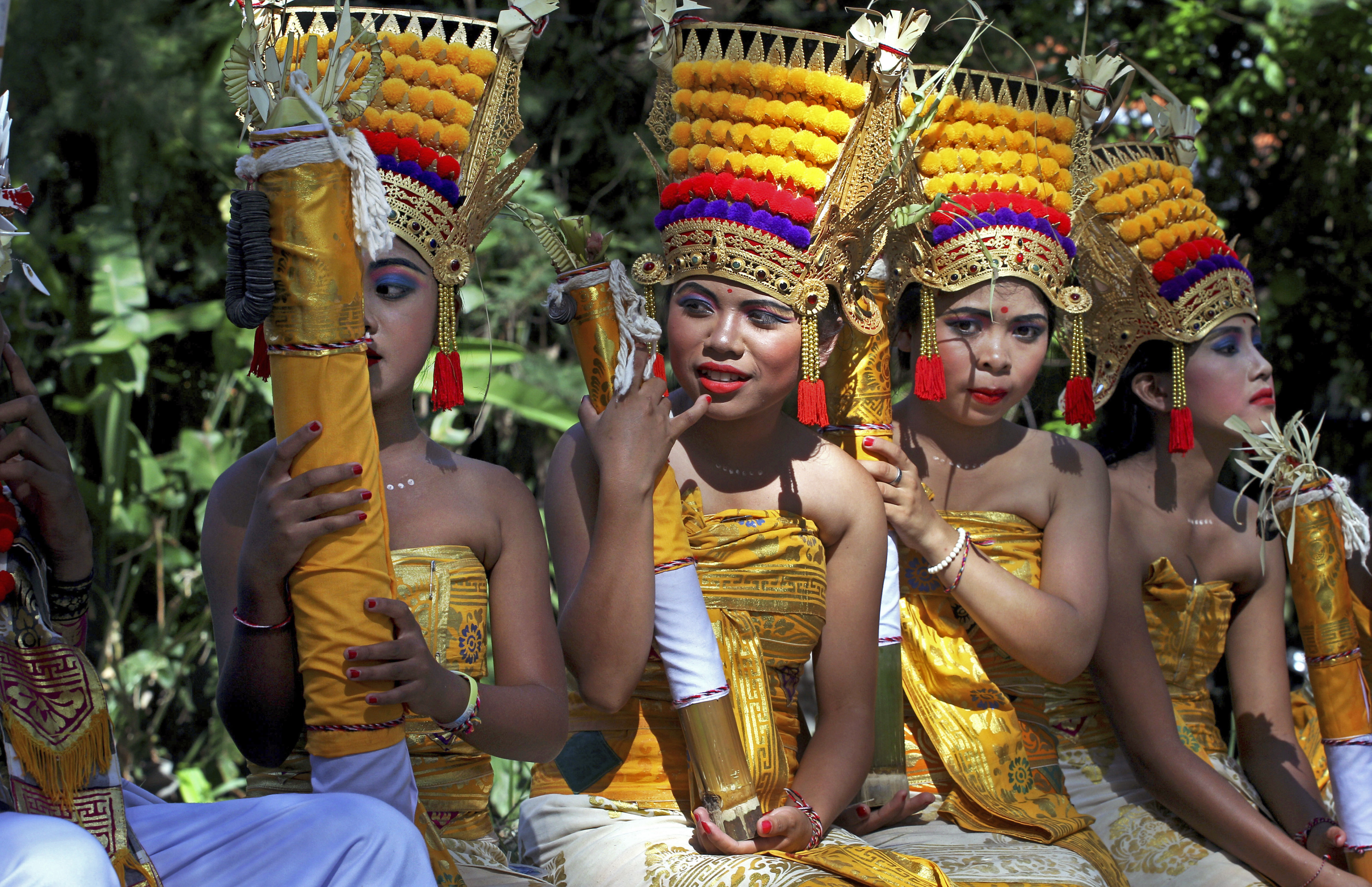 Balinese girls in traditional dress wait for a parade during the Bali Arts Festival in Bali, Indonesia, Saturday, June 10, 2017. A month-long annual festival started on Saturday. (AP Photo/Firdia Lisnawati)