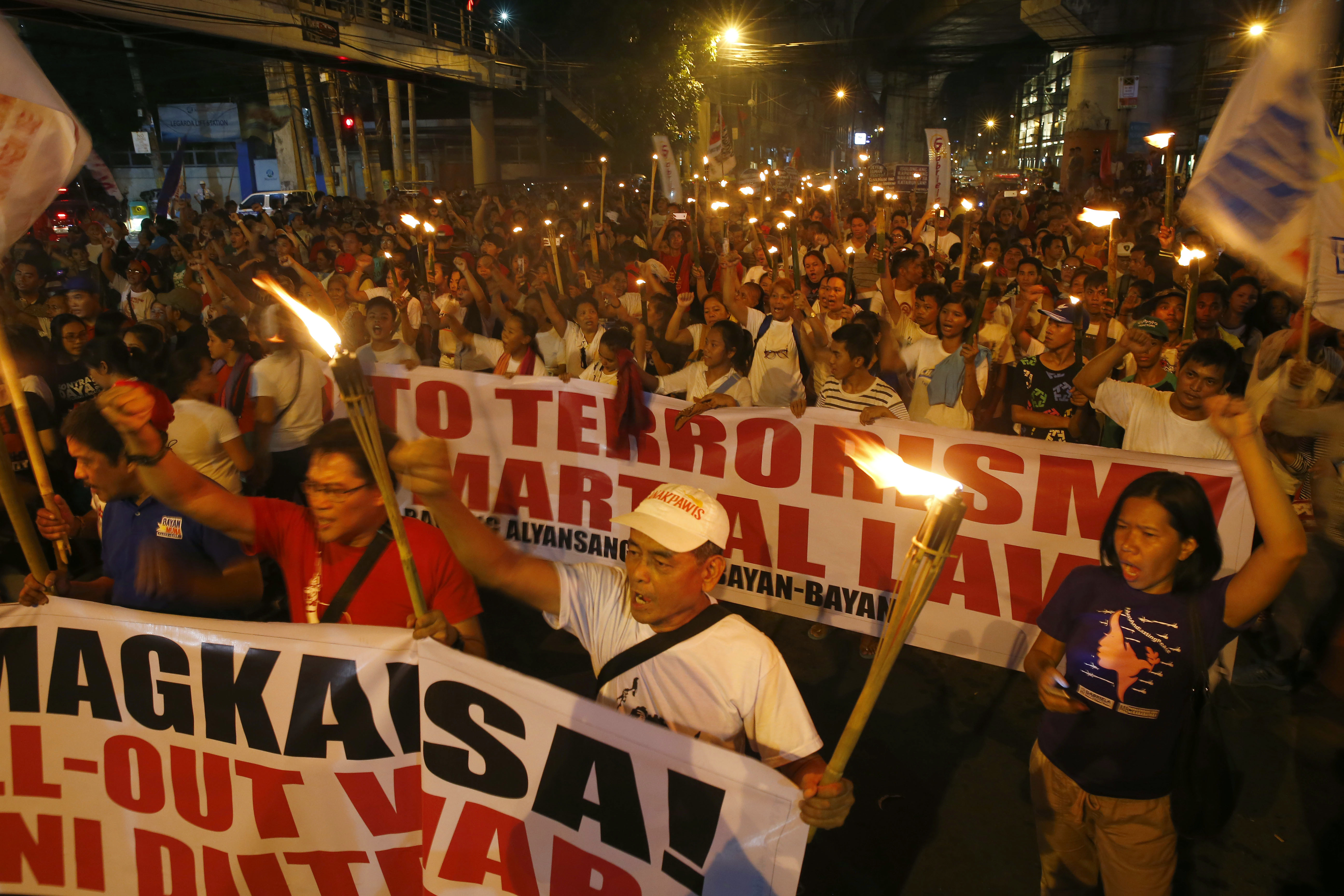Protesters shout slogans during a rally near the Presidential Palace to denounce the Martial Law declaration of President Rodrigo Duterte after Muslim militants laid a siege of Marawi city in southern Philippines for three weeks, Monday, June 12, 2017 in Manila, Philippines. The protesters also denounced the killings by Duterte's anti-drug crackdown. (AP Photo/Bullit Marquez)