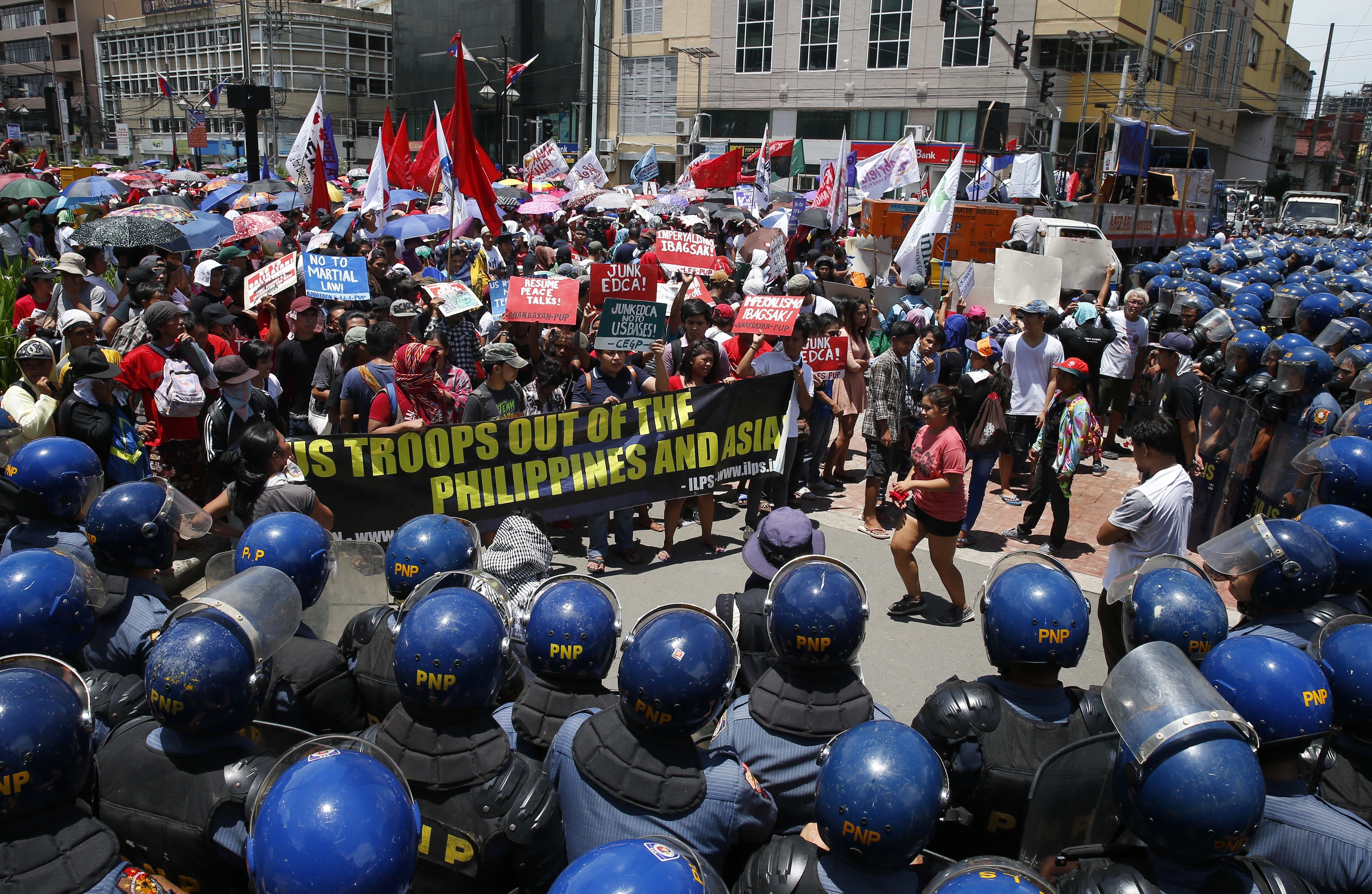 Protesters are blocked by police as they attempt to march closer to the U.S. Embassy to denounce the U.S. military's role in the ongoing battle between Government forces and Muslim militants who laid siege to Marawi city in southern Philippines for three weeks now Monday, June 12, 2017 in Manila, Philippines. The protesters also denounced President Rodrigo Duterte's declaration of Martial Law in the whole region of Mindanao in southern Philippines.(AP Photo/Bullit Marquez)