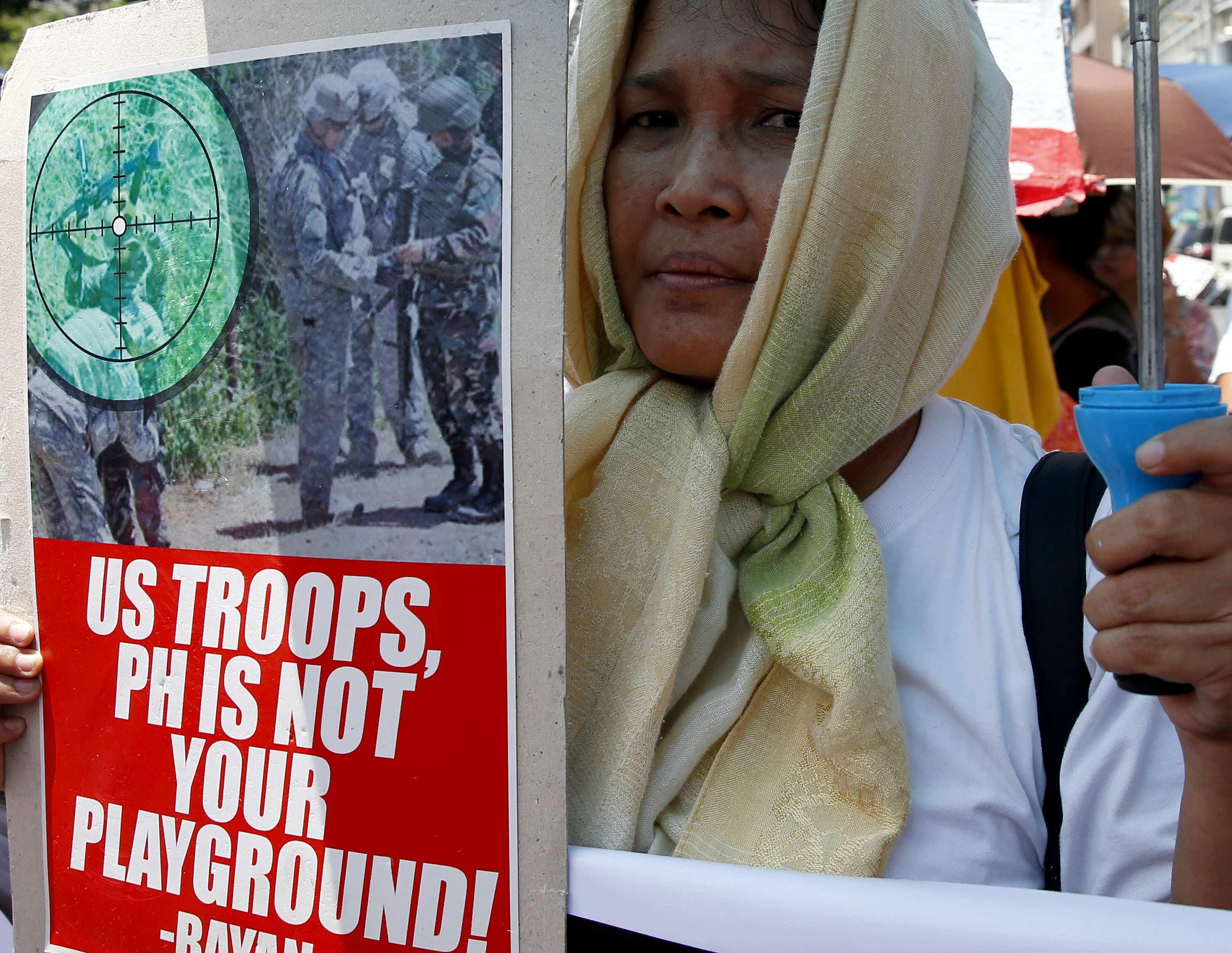 A protester holds a placard during a rally near the U.S. Embassy to denounce the U.S. military's role in the ongoing battle between Government forces and Muslim militants who laid siege to Marawi city in southern Philippines for three weeks now Monday, June 12, 2017 in Manila, Philippines. The protesters also denounced President Rodrigo Duterte's declaration of Martial Law in the whole region of Mindanao in southern Philippines.(AP Photo/Bullit Marquez)