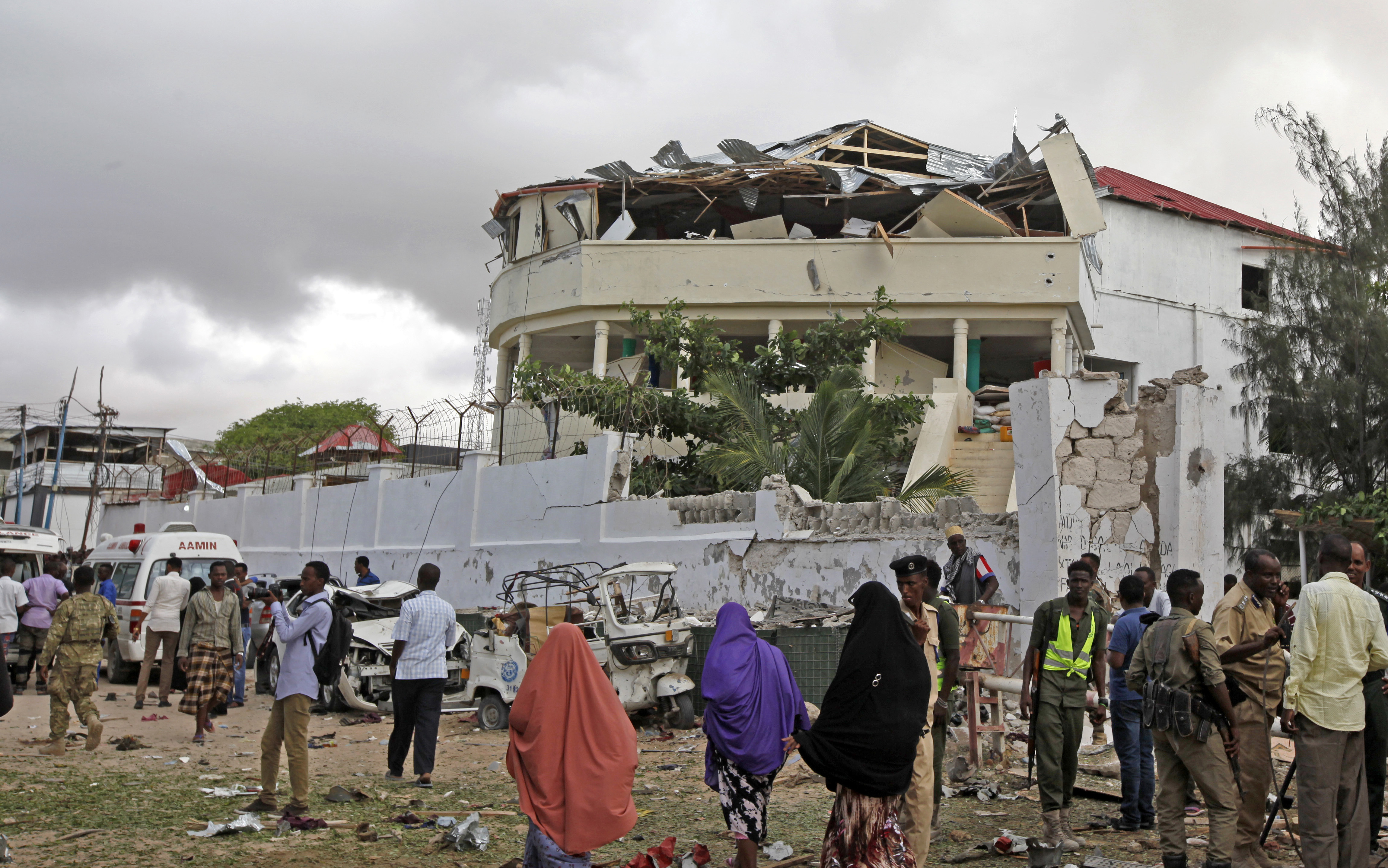 Somalis gather outside a destroyed building near a restaurant that was the scene of a car bomb blast and gun battle in Mogadishu, Somalia Thursday, June 15, 2017. Somali survivors early Thursday described harrowing scenes of the night-long siege of a popular Mogadishu restaurant by al-Shabab Islamic extremists that was ended by security forces. (AP Photo/Farah Abdi Warsameh)