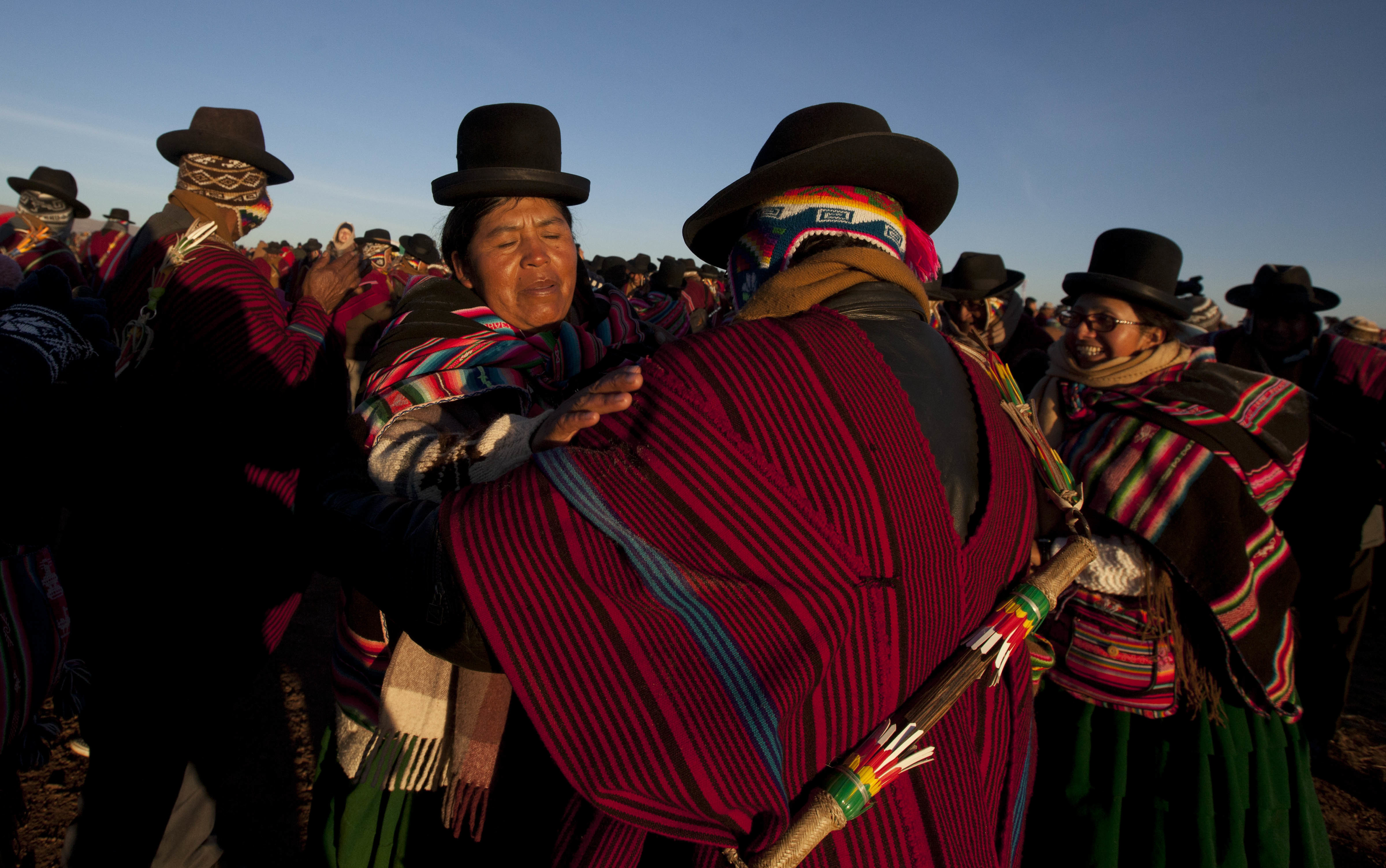 Aymara Indians embrace while receiving the first rays of sunlight in a New Year's ritual at the ruins of the ancient city Tiwanaku, Bolivia, early Wednesday, June 21, 2017. Bolivia's Aymara Indians are celebrating the year 5,525 as well as the Southern Hemisphere's winter solstice, which marks the start of a new agricultural cycle. (AP Photo/Juan Karita)