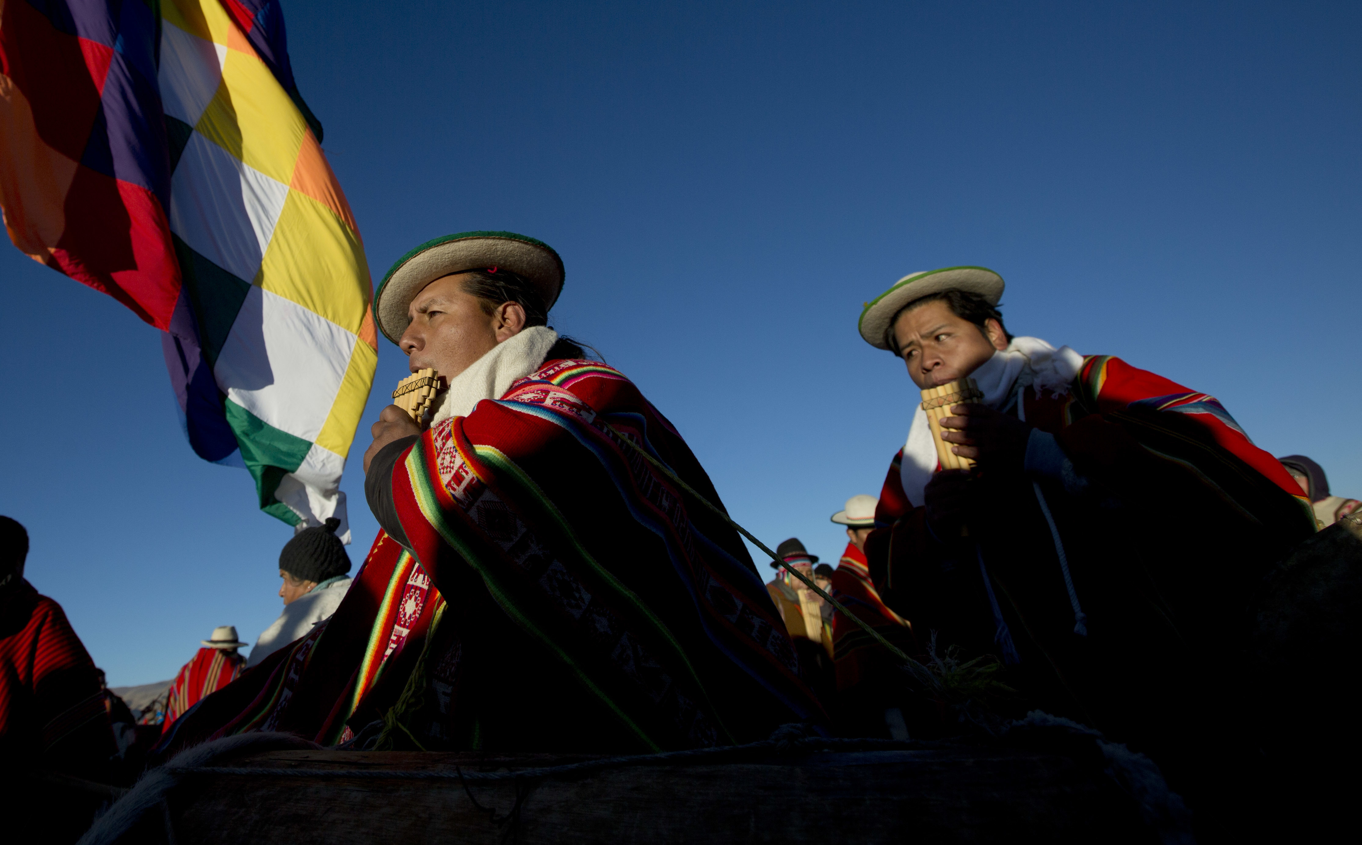 Aymara indigenous musicians play flutes and drums after receiving the first rays of sunlight during a New Year's ritual in the ruins of the ancient city Tiwanaku, Bolivia, early Tuesday, June 21, 2016. Bolivia's Aymara Indians are celebrating the year 5,524 as well as the Southern Hemisphere's winter solstice, which marks the start of a new agricultural cycle. (AP Photo/Juan Karita)