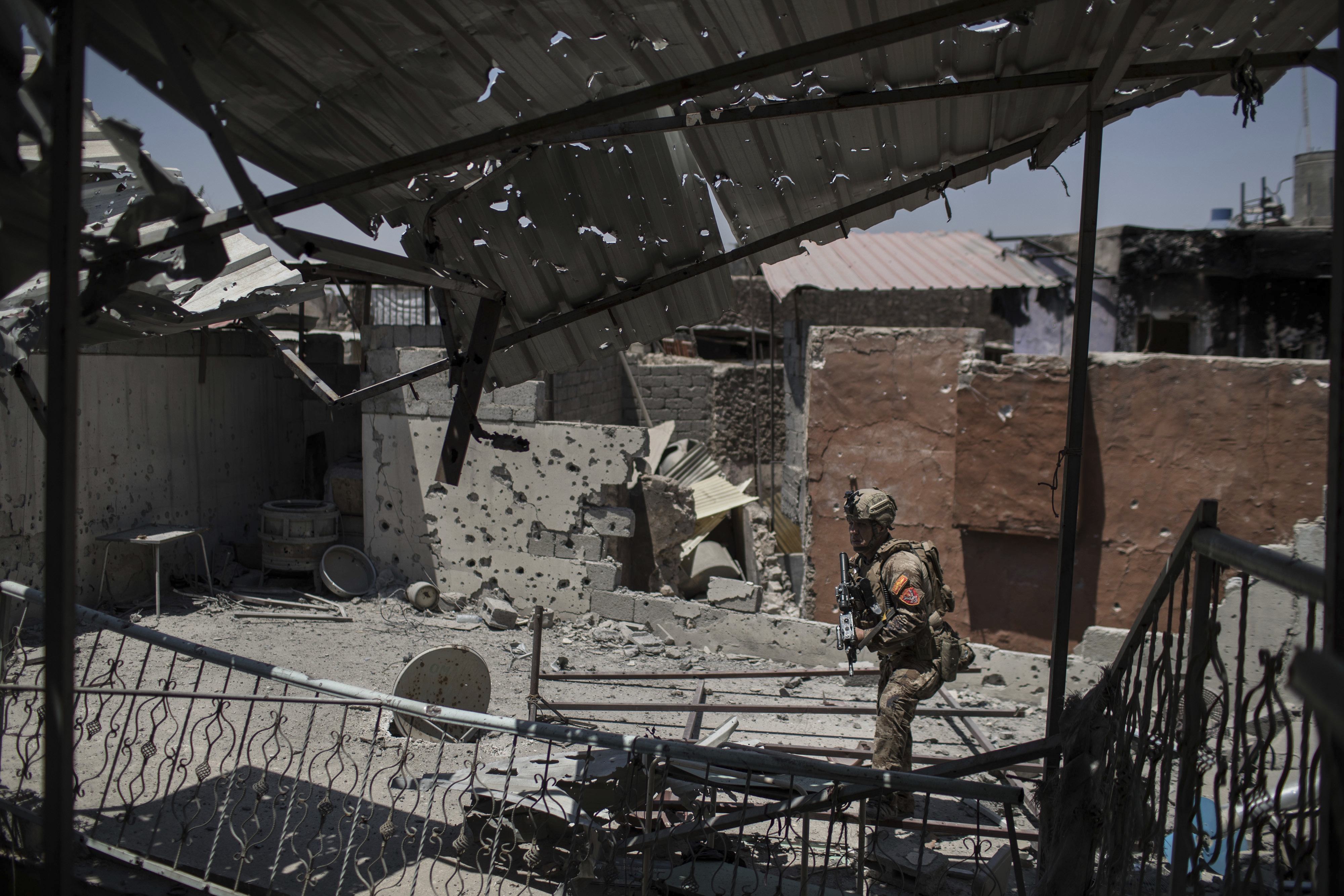 An Iraqi special forces soldier walks by a damaged house during fighting against Islamic State militants in the Old City of Mosul, Iraq, Tuesday, June 27, 2017. An Iraqi officer says counterattacks by Islamic State militants on the western edge of Mosul have stalled Iraqi forces' push in the Old City _ the last IS stronghold in the city. (AP Photo/Felipe Dana)