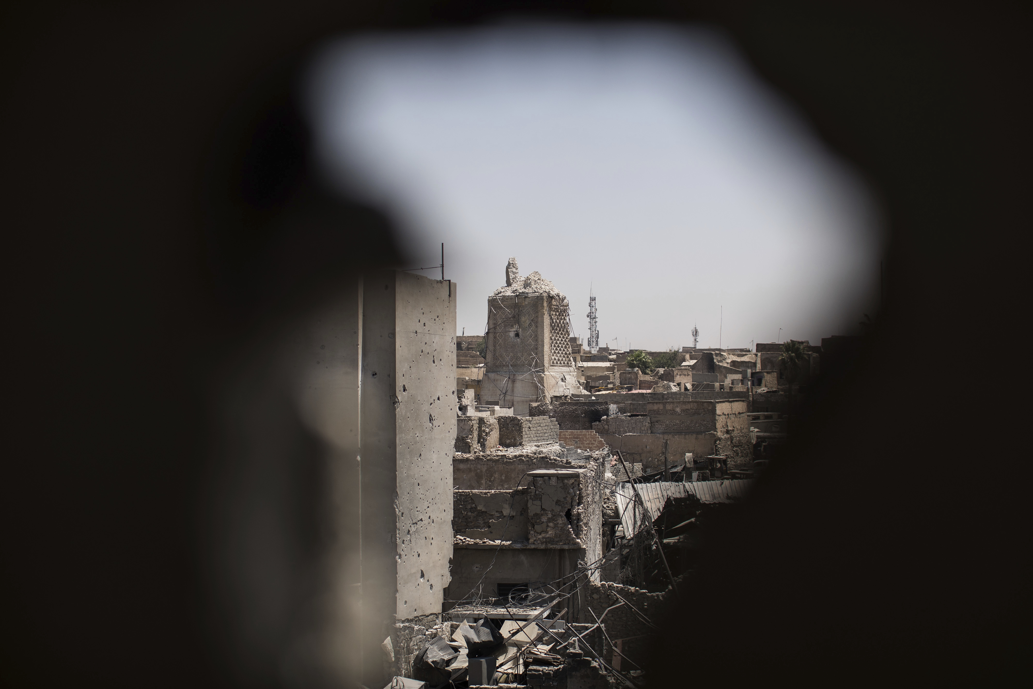 The destroyed al-Nuri mosque is seen through a hole in the wall of a house retaken by Iraqi Special Forces during fighting against Islamic State militants in the Old City of Mosul, Iraq, Tuesday, June 27, 2017. An Iraqi officer says counterattacks by Islamic State militants on the western edge of Mosul have stalled Iraqi forces' push in the Old City _ the last IS stronghold in the city. (AP Photo/Felipe Dana)
