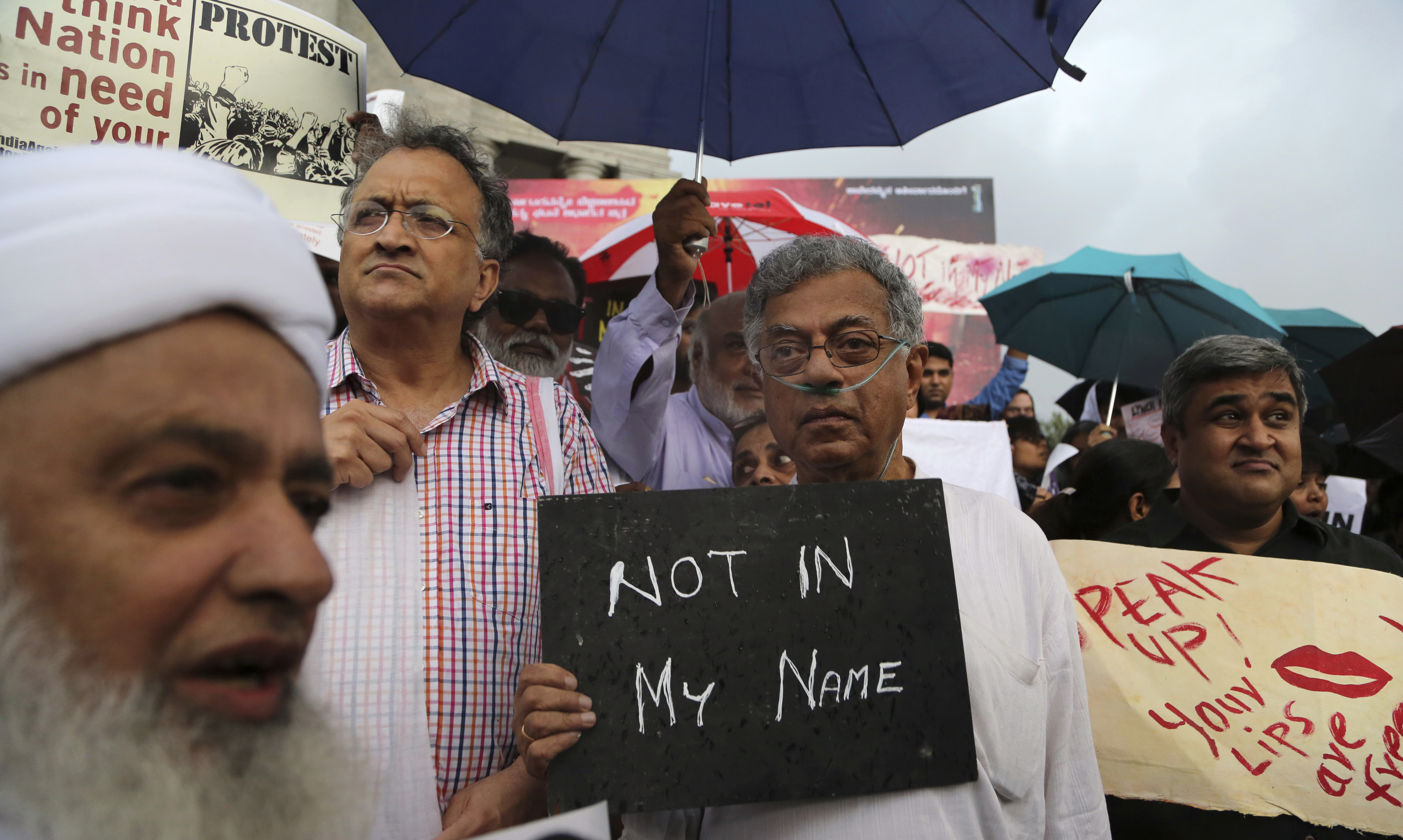 Indian actor Girish Karnad, center, holds a placard during a protest against a spate of violent attacks across the country targeting the country's Muslim minority, in Bangalore, India, Wednesday, June 28, 2017. Thousands of protestors gathered in different cities to decry the silence of India's Hindu right-wing government in the face of the public lynchings and violent attacks on at least a dozen Muslim men and boys since it was voted to power in 2014. (AP Photo/Aijaz Rahi)
