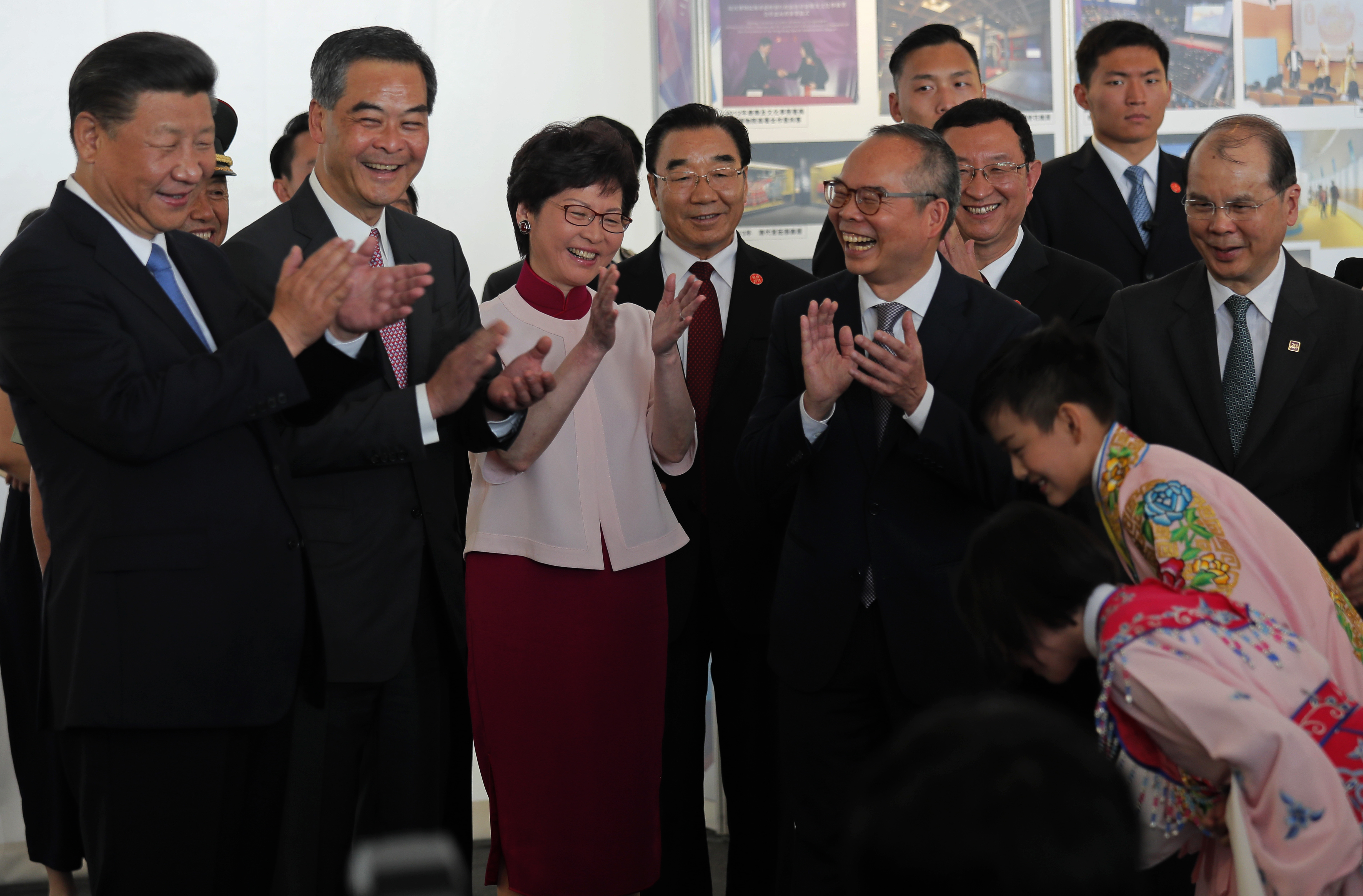 Chinese President Xi Jinping, left, Hong Kong Chief Executive Leung Chun-ying, second left, and Chief Executive-elect Carrie Lam, third left, applaud after watching two young Chinese opera performers during a visit to Hong Kong's West Kowloon district Thursday, June 29, 2017, the site of a controversial high speed cross-border rail terminus. Pro-democracy supporters fear that a plan to station mainland Chinese immigration agents in the terminal to check passengers departing on trains for the mainland is an erosion of Hong Kong's 