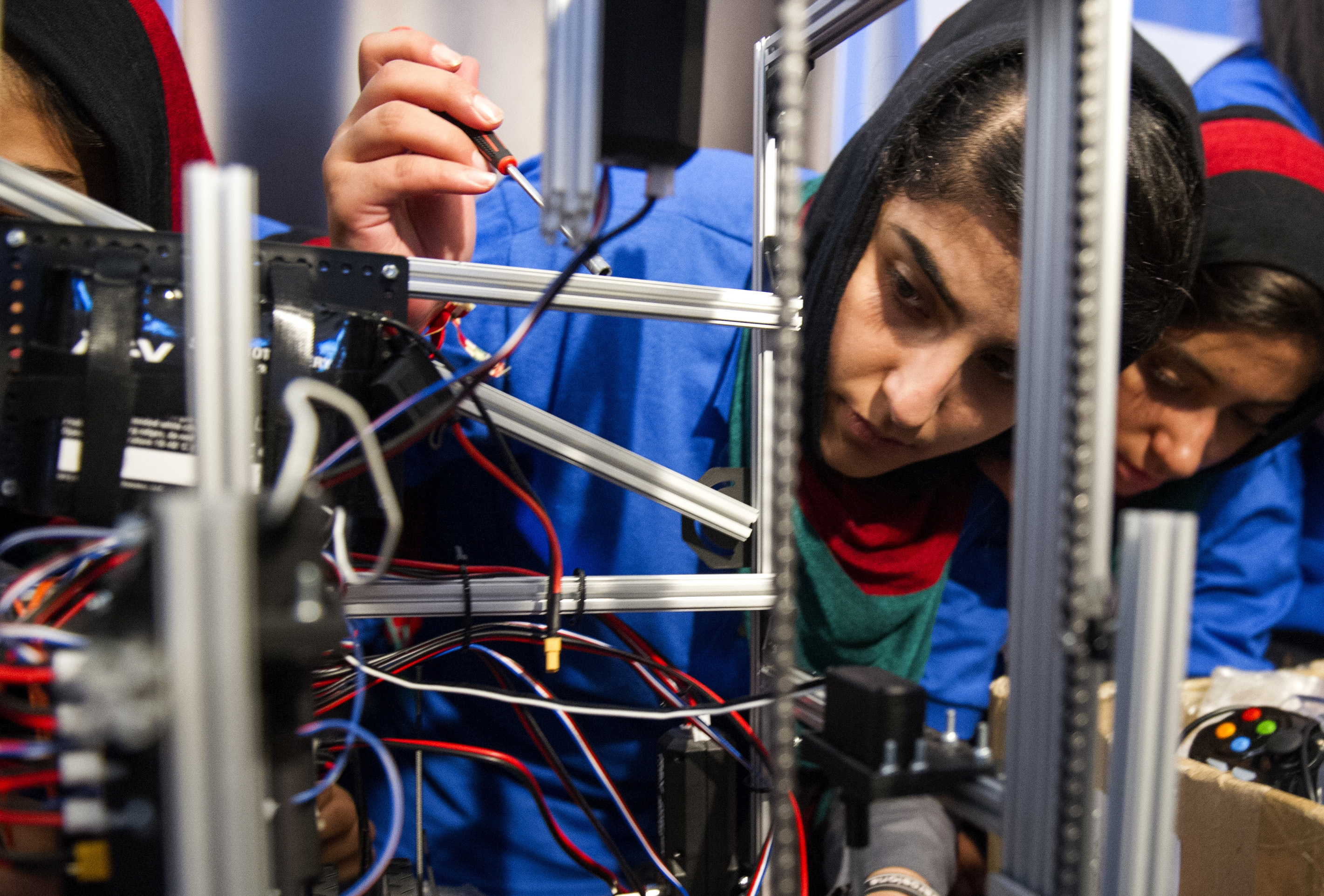 Afghanistan team member Lisa Azizi troubleshoots the team's robot entry prior to the opening ceremony for the FIRST Global Challenge in Washington, Sunday, July 16, 2017. They will be competing against entrants from more than 150 countries in the international competition. It's the first annual robotics competition designed to encourage youths to pursue careers in math and science. (AP Photo/Cliff Owen)