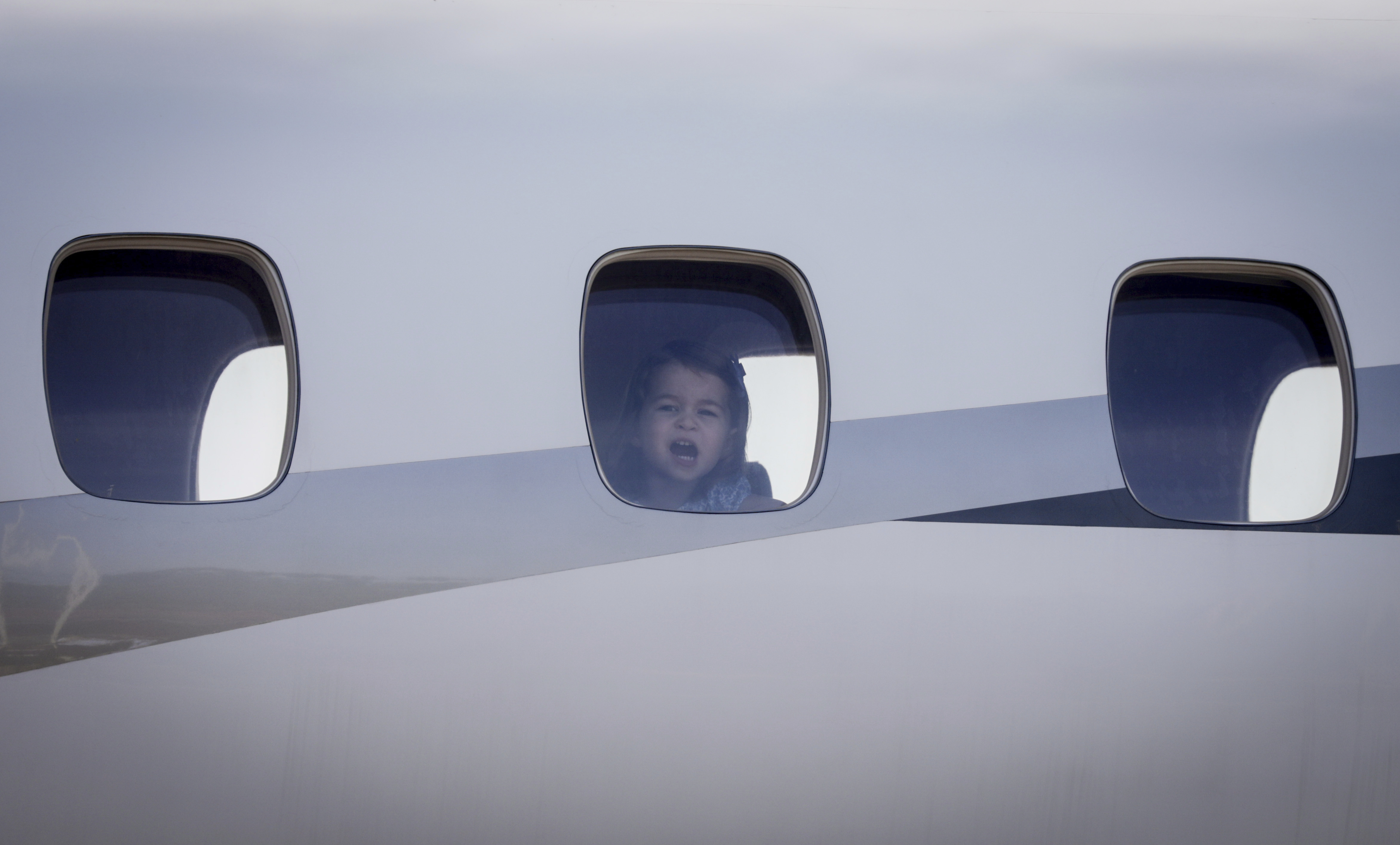 Charlotte, the daughter of Britain's Prince William and his wife Catherine, Duchess of Cambridge, looks out of the window of the plane on arrival at Tegel Airport in Berlin, Germany, 19 July 2017. Photo by: Kay Nietfeld/picture-alliance/dpa/AP Images