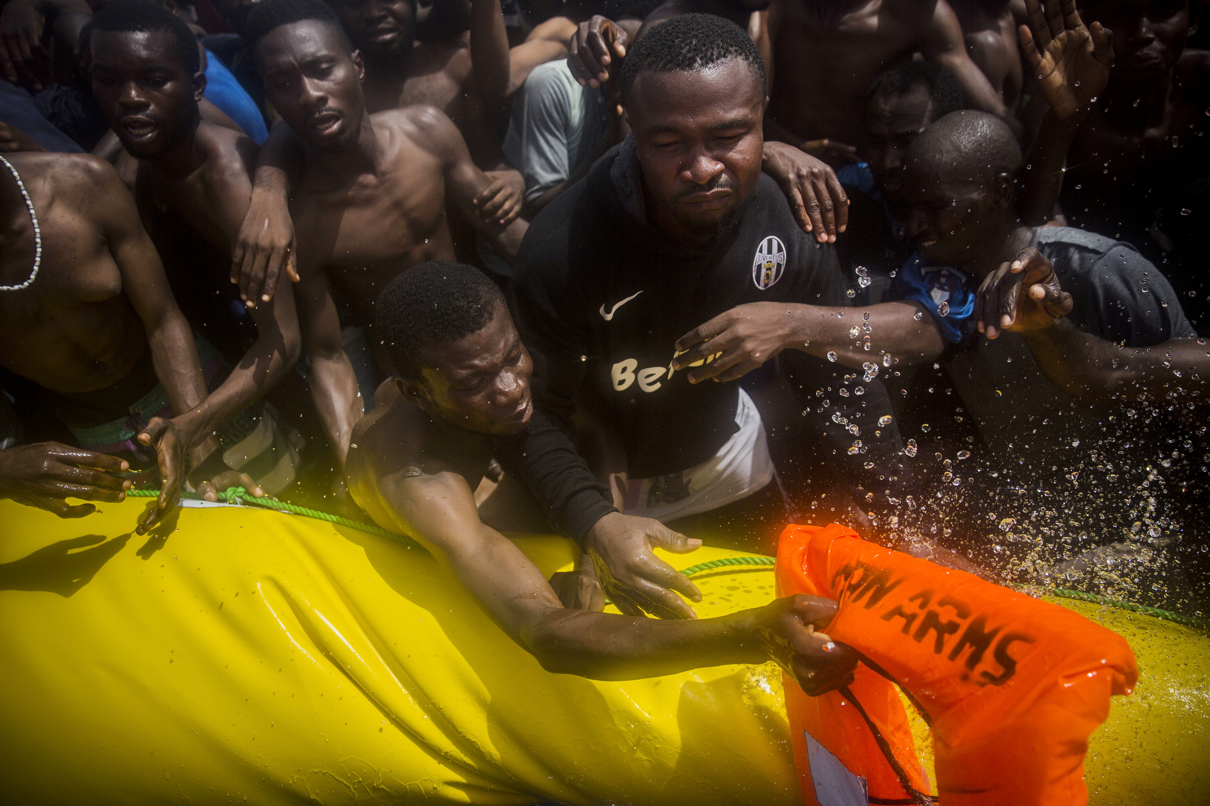 Sub saharan migrants receive life jackets as they are rescued by aid workers of Spanish NGO Proactiva Open Arms in the Mediterranean Sea, about 15 miles north of Sabratha, Libya on Tuesday, July 25, 2017. (AP Photo/Santi Palacios)