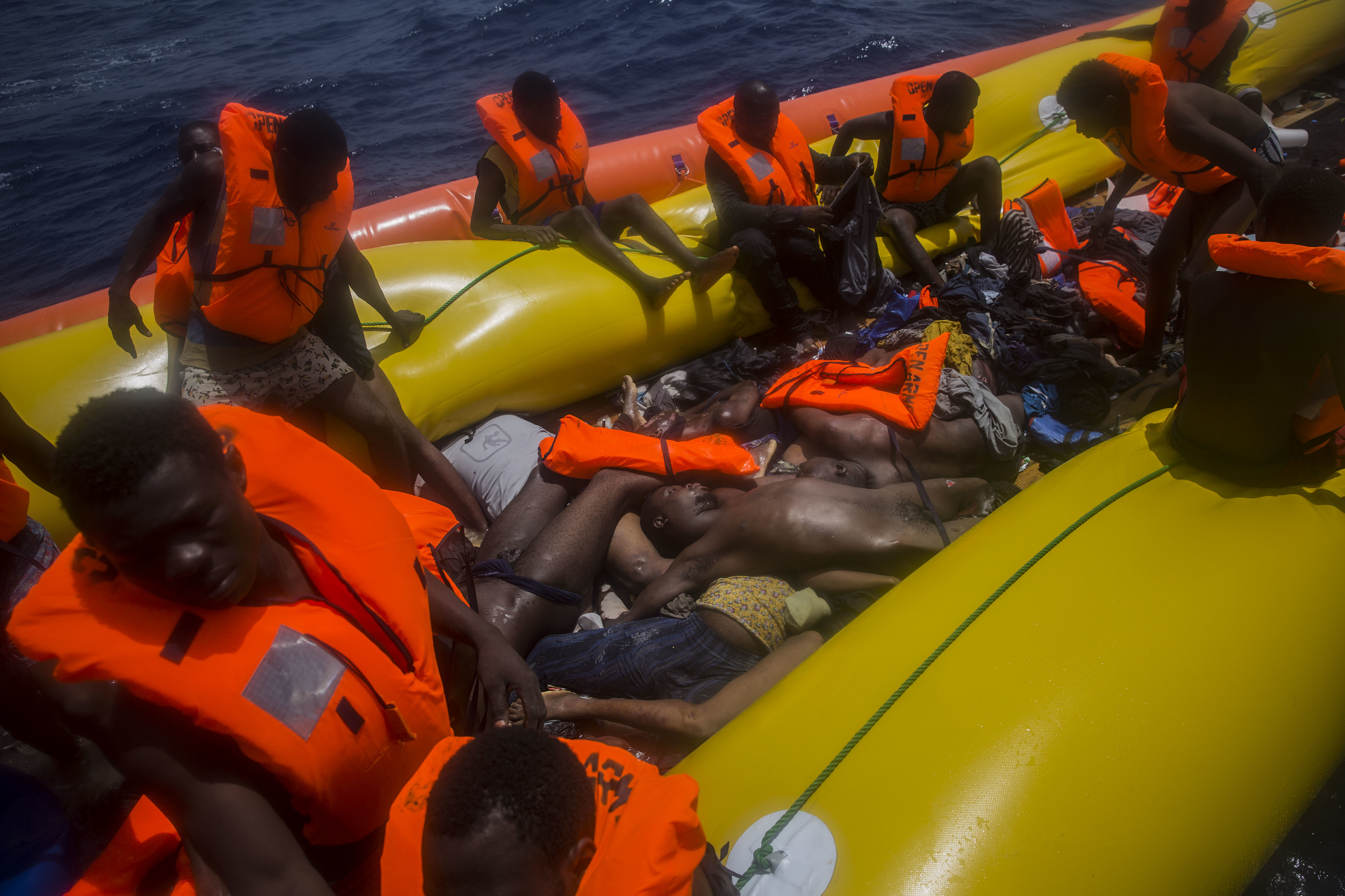 EDS NOTE: GRAPHIC CONTENT - Migrants wait to be rescued by aid workers of Spanish NGO Proactiva Open Arms next to dead bodies of other migrants in the Mediterranean Sea, about 15 miles north of Sabratha, Libya on Tuesday, July 25, 2017. (AP Photo/Santi Palacios)