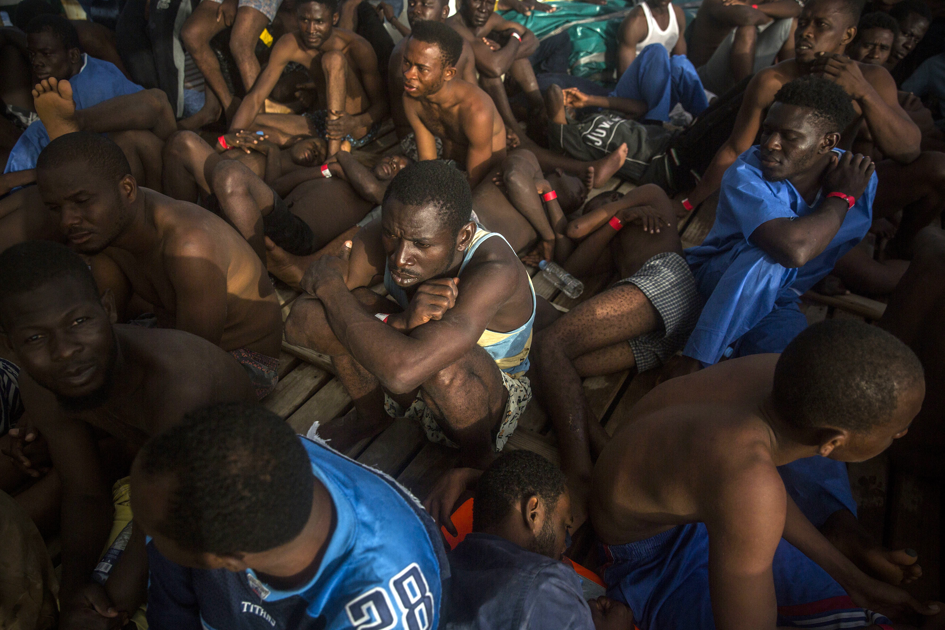 Sub saharan migrants sit on the deck of the vessel of Proactiva Open Arms after being rescued in the Mediterranean Sea, about 15 miles north of Sabratha, Libya on Tuesday, July 25, 2017. More than 120 migrants were rescued Tuesday from the Mediterranean Sea while 13 more —including pregnant women and children— died in a crammed rubber raft, according to a Spanish rescue group. (AP Photo/Santi Palacios)