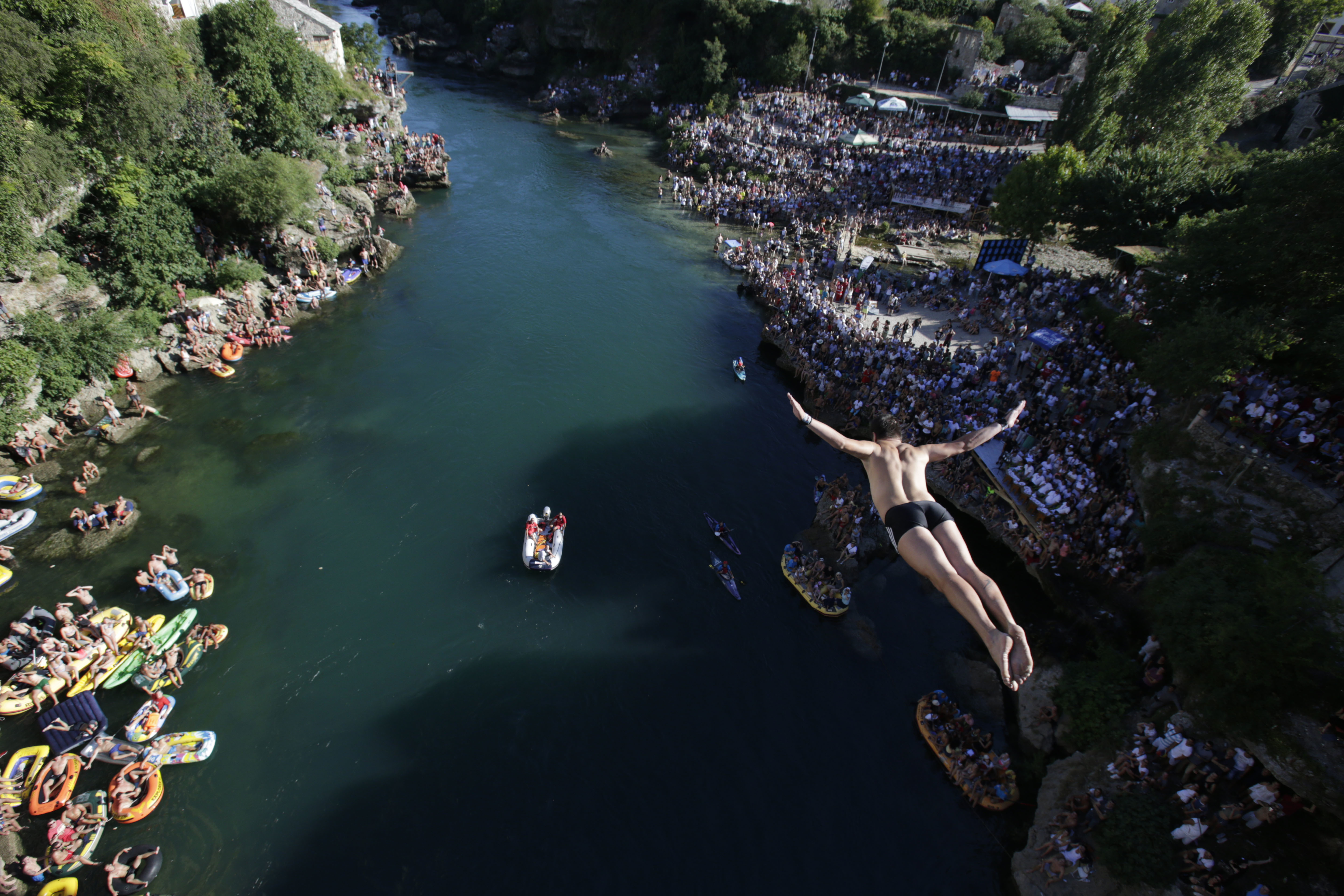 A diver drops through the air from the Mostar bridge during the 451th traditional annual high diving competition, in Mostar, 140 kms south of Bosnian capital of Sarajevo, Sunday, July 30, 2017. Total of 41 divers from Bosnia and neighbouring countries competed diving from 25 meters high Old Mostar Bridge into the Neretva river. (AP Photo/Amel Emric)