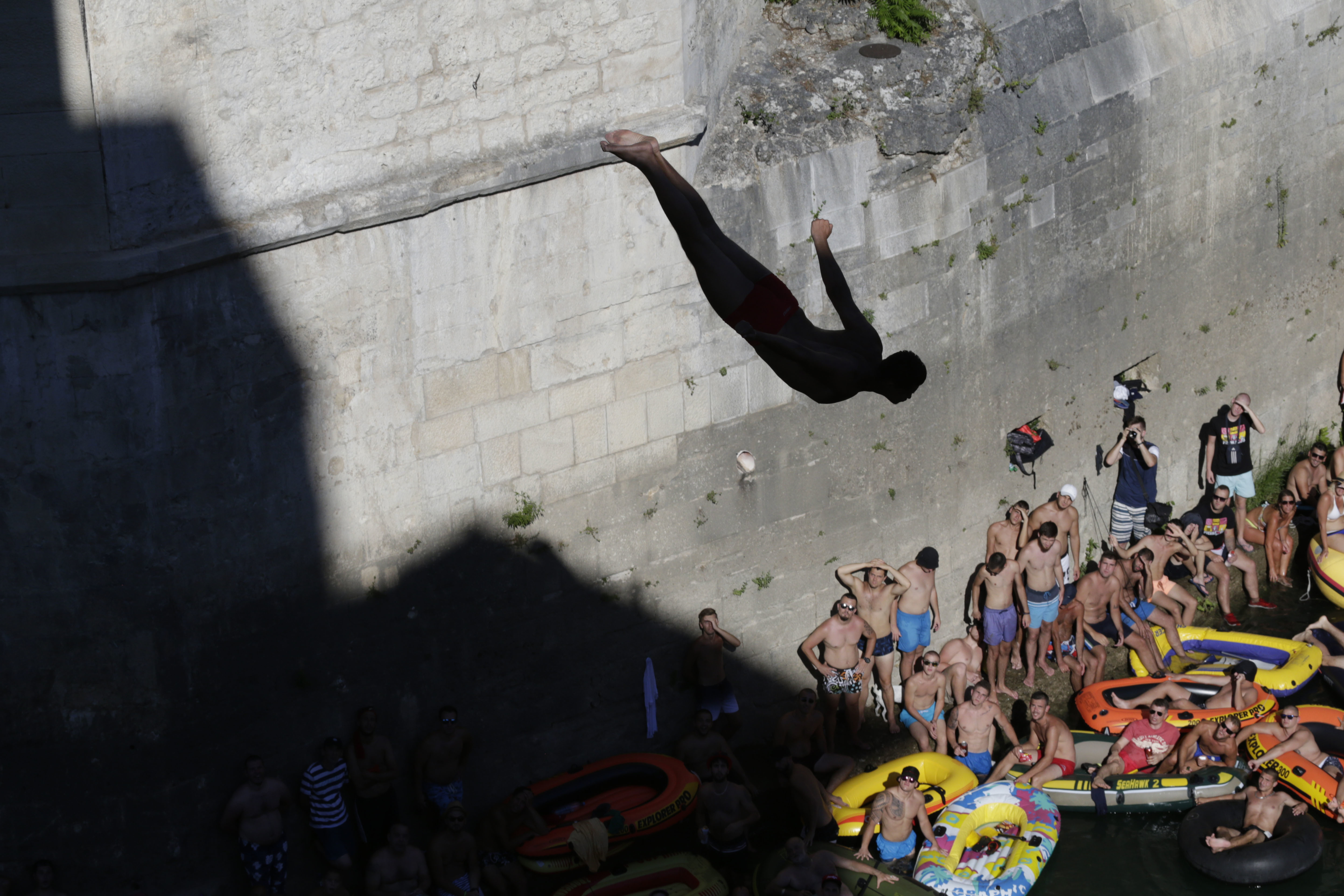 Spectators watch as a diver jumps from the Old Mostar Bridge during 451th traditional annual high diving competition, in Mostar, 140 kms south of Bosnian capital of Sarajevo, Sunday, July 30, 2017. Total of 41 divers from Bosnia and neighbouring countries competed diving from 25 meters high Old Mostar Bridge into the Neretva river. (AP Photo/Amel Emric)