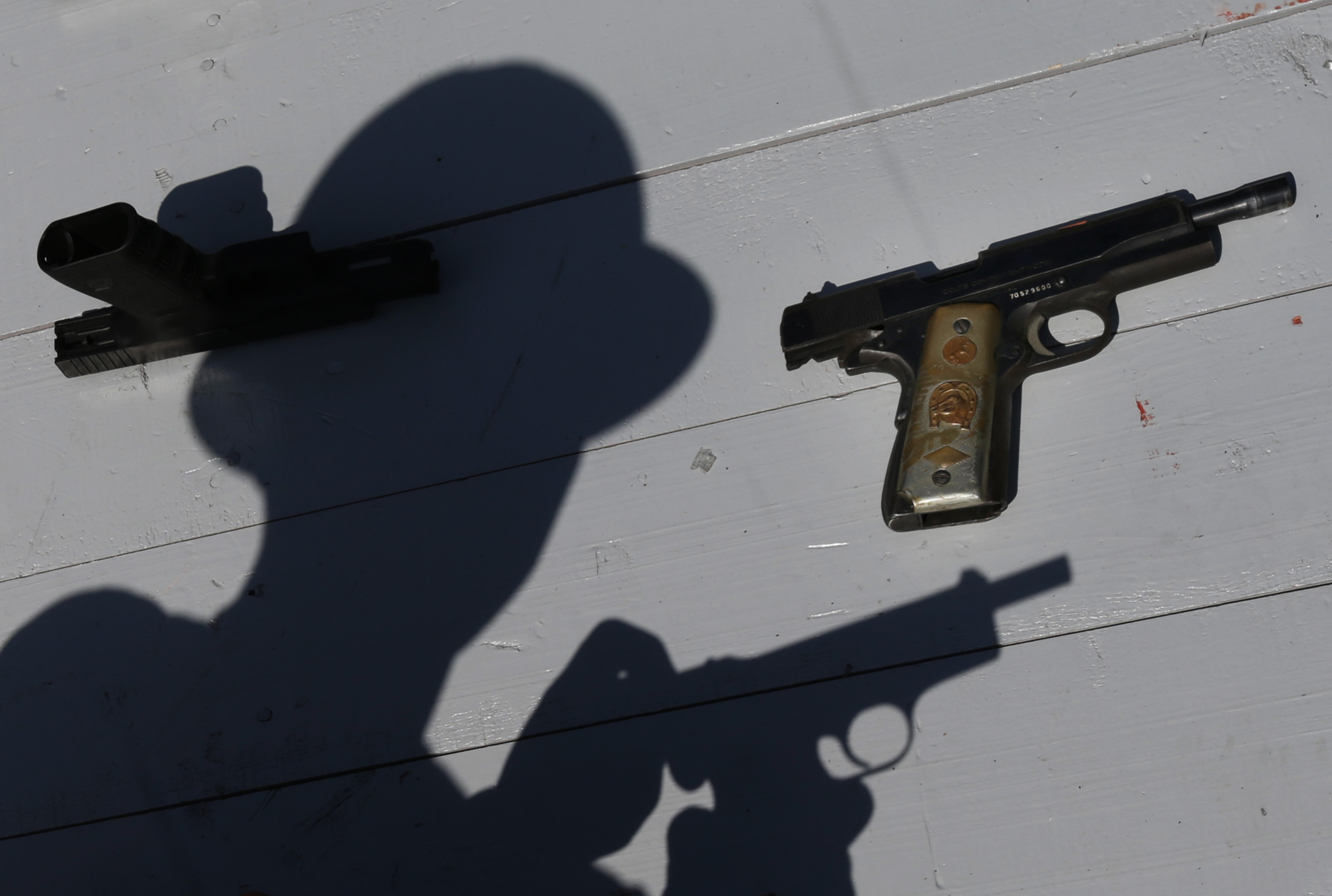 A Mexican army soldier shows a set of hand guns sporting a gold plated grips, part of a lot of weapons slated for destruction by the Mexican army in Mexico City, Tuesday, Aug. 1, 2017. The weapons were confiscated from organized crime and civilians who turned them in. (AP Photo/Marco Ugarte)