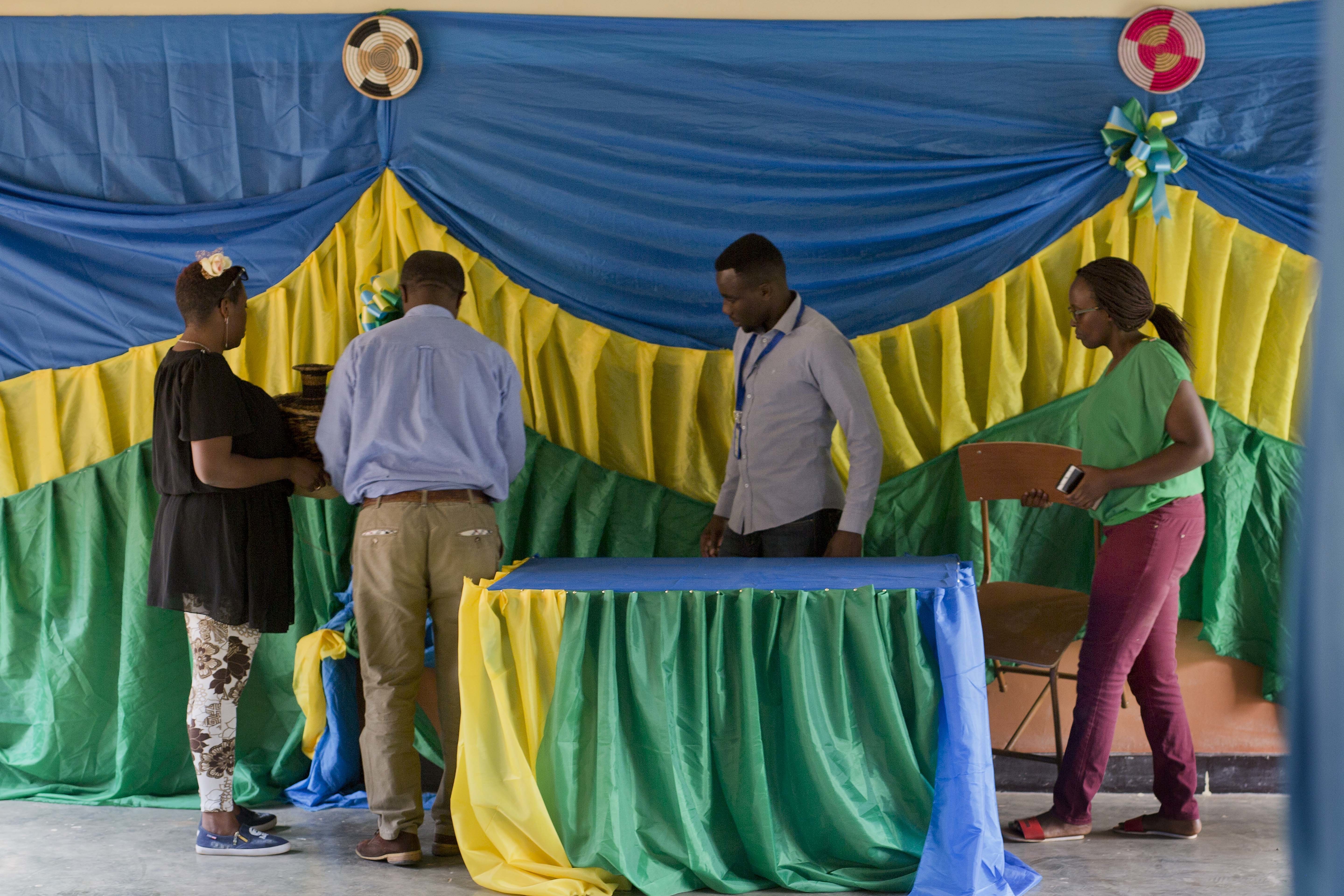 Election volunteers decorate a polling station in Rwanda's capital Kigali Thursday Aug. 3, 2017, in preparation for the presidential election on Friday in which outgoing president Paul Kagame is widely expected to win another term after the government earlier disqualified all but three candidates. (AP Photo/Jerome Delay)