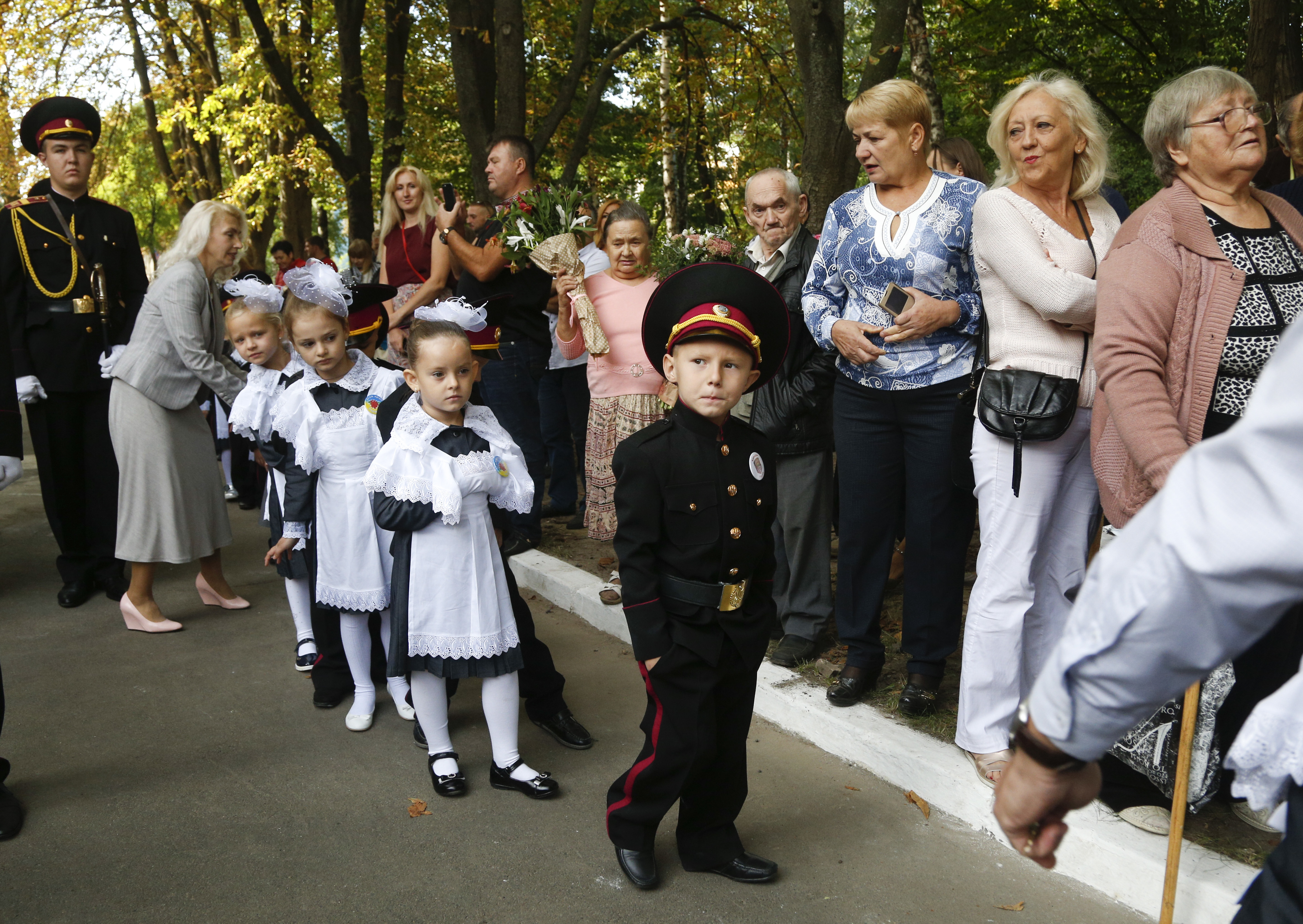 Relatives and schoolchildrens wait for a ceremony on the occasion of the first day of school at a cadet lyceum in Kiev, Ukraine, Friday, Sept. 1, 2017. Ukraine marks Sept. 1 as Knowledge Day, as a traditional launch of the academic year. (AP Photo/Efrem Lukatsky)