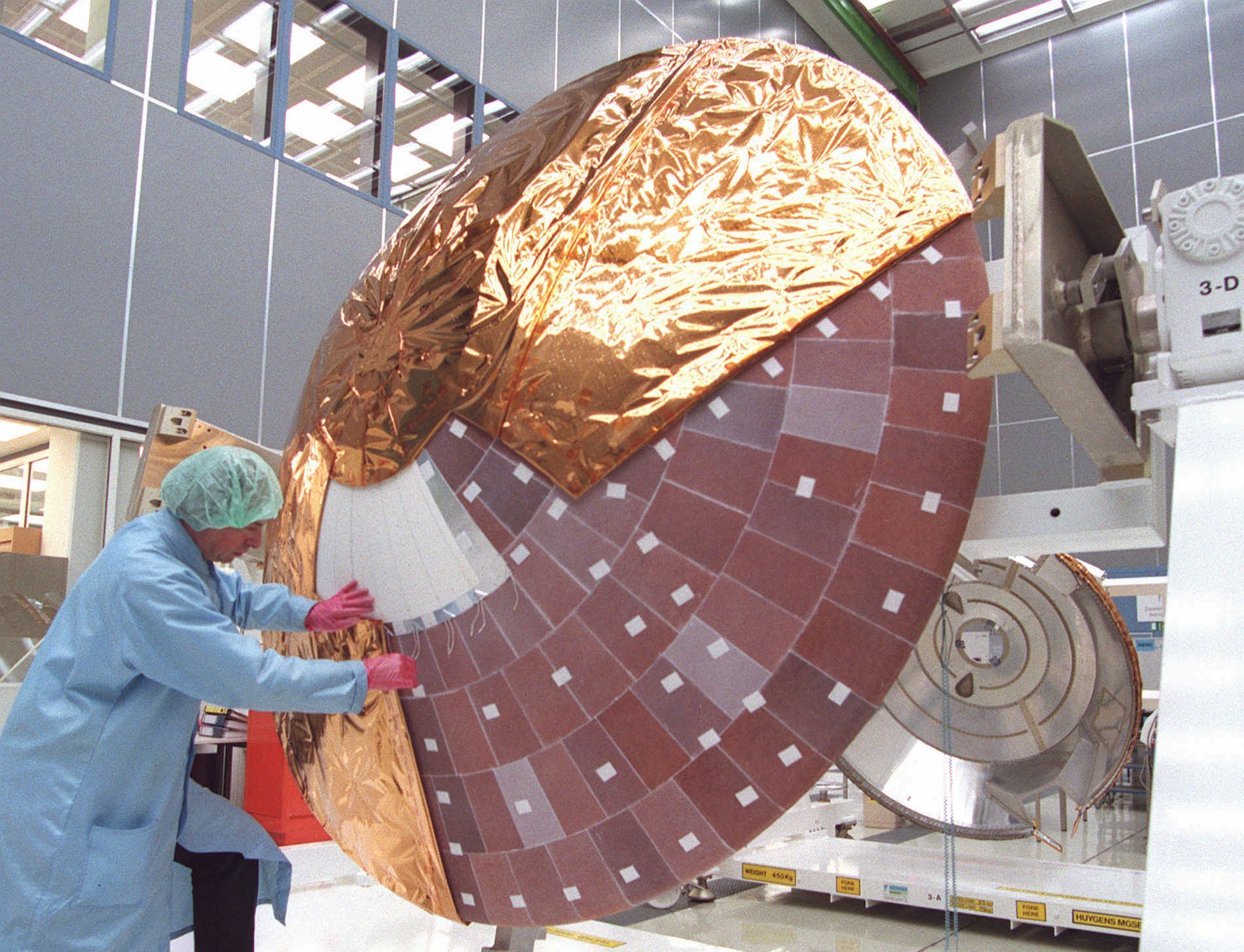 FILE - In this Wednesday, March 26, 1997 file photo, a technician checks the heatshield of the space probe Huygens in the cleanroom of Dornier Satellitensysteme GmbH in Ottobrunn, Germany, near Munich. The probe will be carried by NASA's Cassini orbiter and is designed to explore Saturn's moon Titan. (AP Photo/Uwe Lein)
