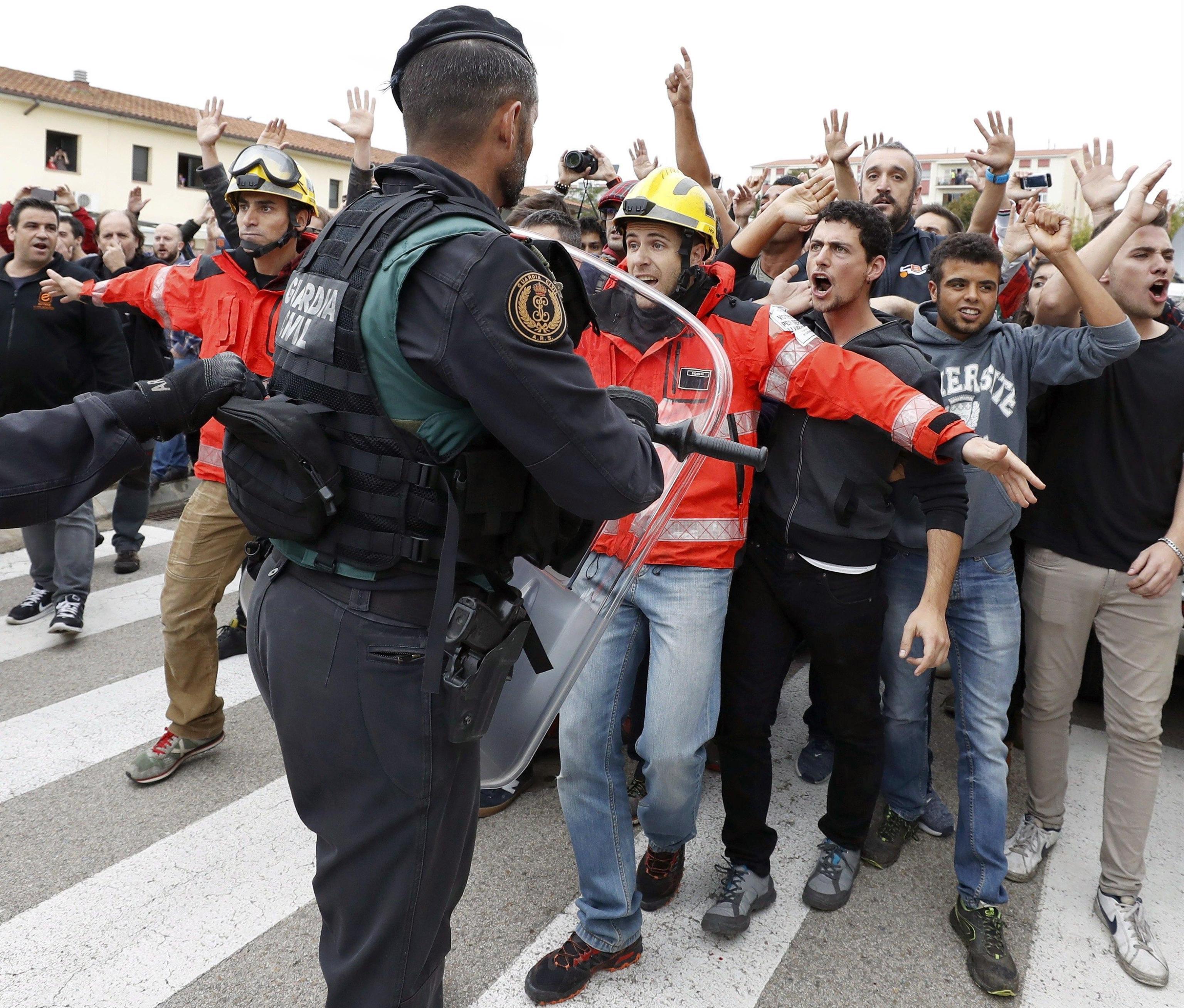 Firemen try to hold back Catalan pro-independence people as clashes take place with Spanish Civil guards at a polling center at Sant Julia de Ramis sports center in Girona, where the Catalan President, Carles Puigdemont, was initially to vote, in Girona, Catalonia, northeastern Spain, on 01 October 2017. Spanish National Police officers and Civil guards have been deployed to prevent the people from entering to the polling centers to vote in the Catalan independence referendum, that has been banned by the Spanish Constitutional Court, but many people have managed to do it. The police action has provocked clashes between pro-independence people and the police forces in some polling centers. EFE/Andreu Dalmau  EPA/Andreu Dalmau