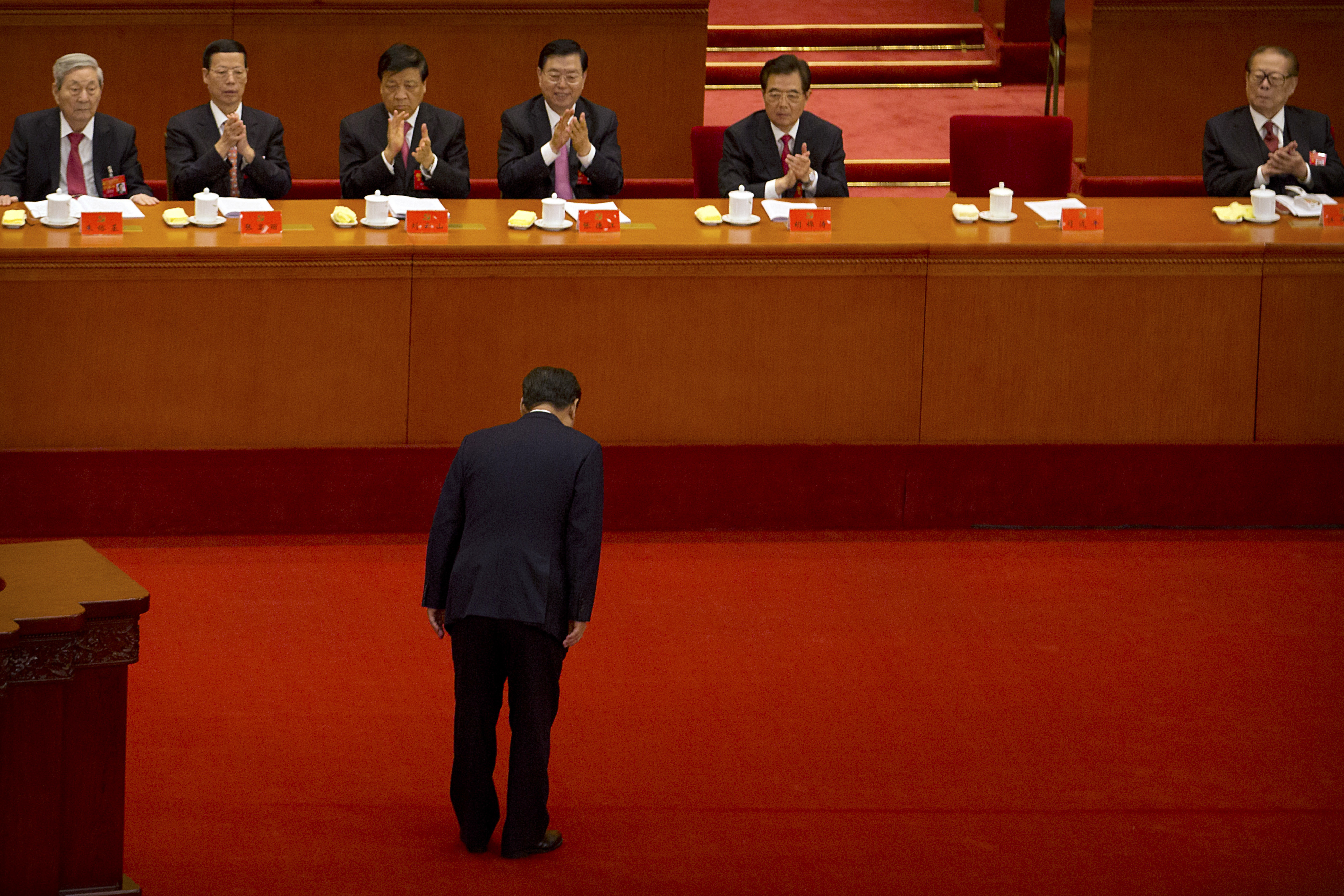 Chinese President Xi Jinping bows to current and former Chinese leaders, from left, former Premier Zhu Rongji, Politburo Standing Committee members Zhang Gaoli, Liu Yunshan, and Zhang Dejiang, former Chinese President Hu Jintao, and former Chinese President Jiang Zemin after giving a speech during the opening session of China's 19th Party Congress at the Great Hall of the People in Beijing, Wednesday, Oct. 18, 2017. Xi on Wednesday urged a reinvigorated Communist Party to take on a more forceful role in society and economic development to better address 