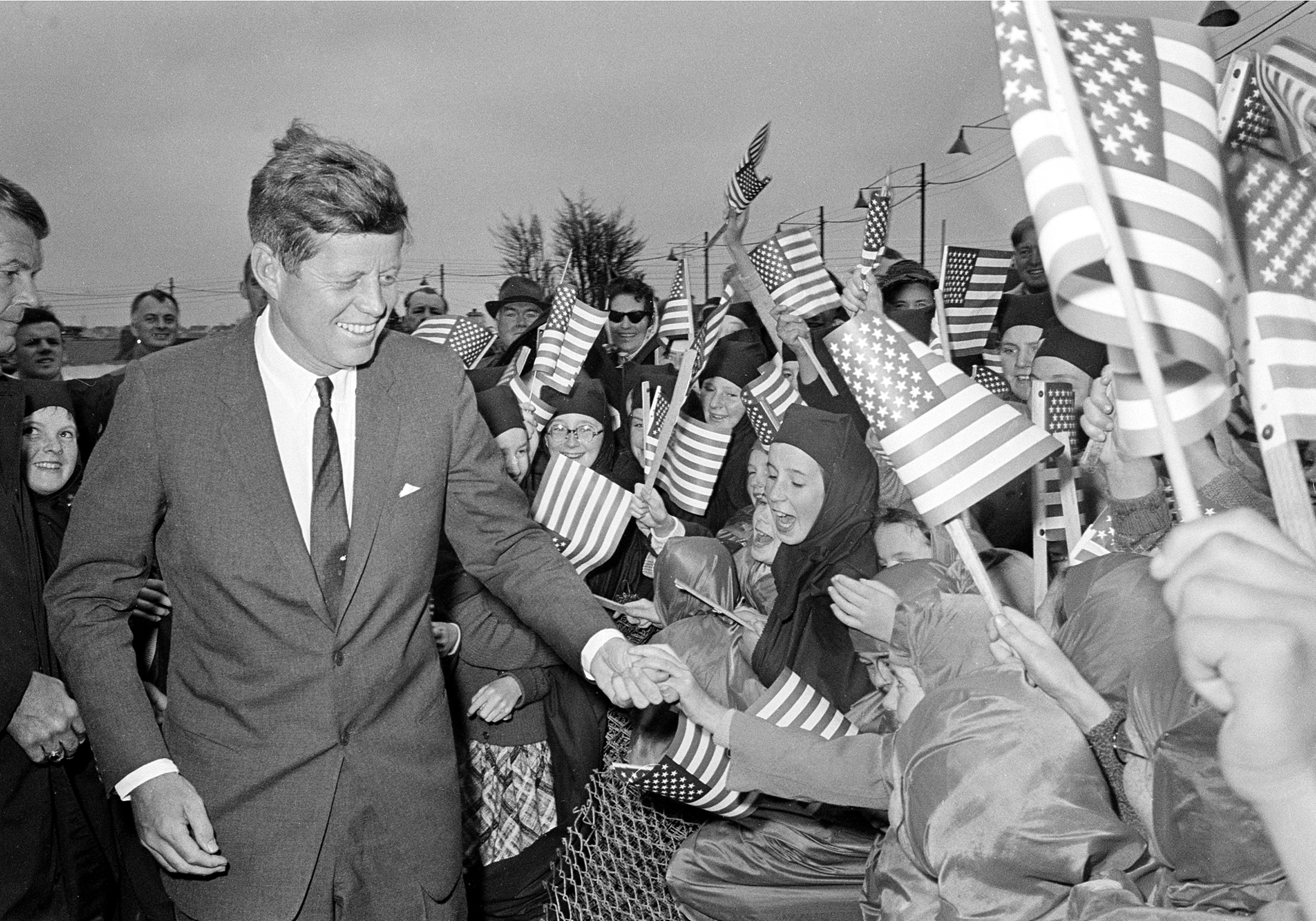 U.S. President John F. Kennedy is greeted by an enthusiastic crowd of children and nuns from the Convent of Mercy, as he arrives from Dublin by helicopter at Galway's sports ground, Ireland, June 29, 1963. (AP Photo)