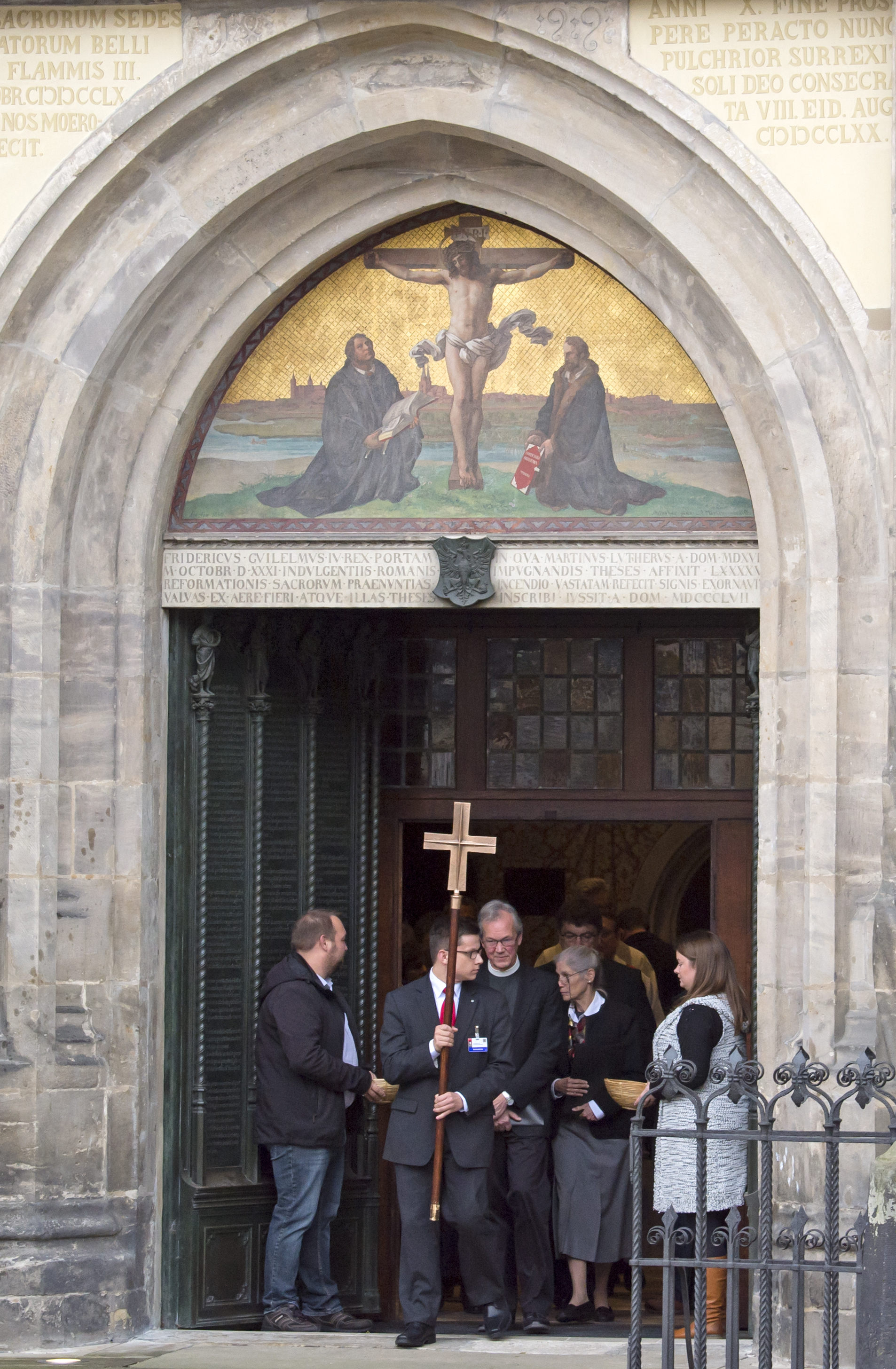 Believers leave  after a public service on the occasion the 500th Anniversary of the Reformation in the Castle Church Wittenberg, Germany, Tuesday, Oct. 31, 2017. German leaders will mark the 500th anniversary of the day Martin Luther is said to have nailed his theses challenging the Catholic Church's practice of selling indulgences to a church door, a starting point of the Reformation. (AP Photo/Jens Meyer)