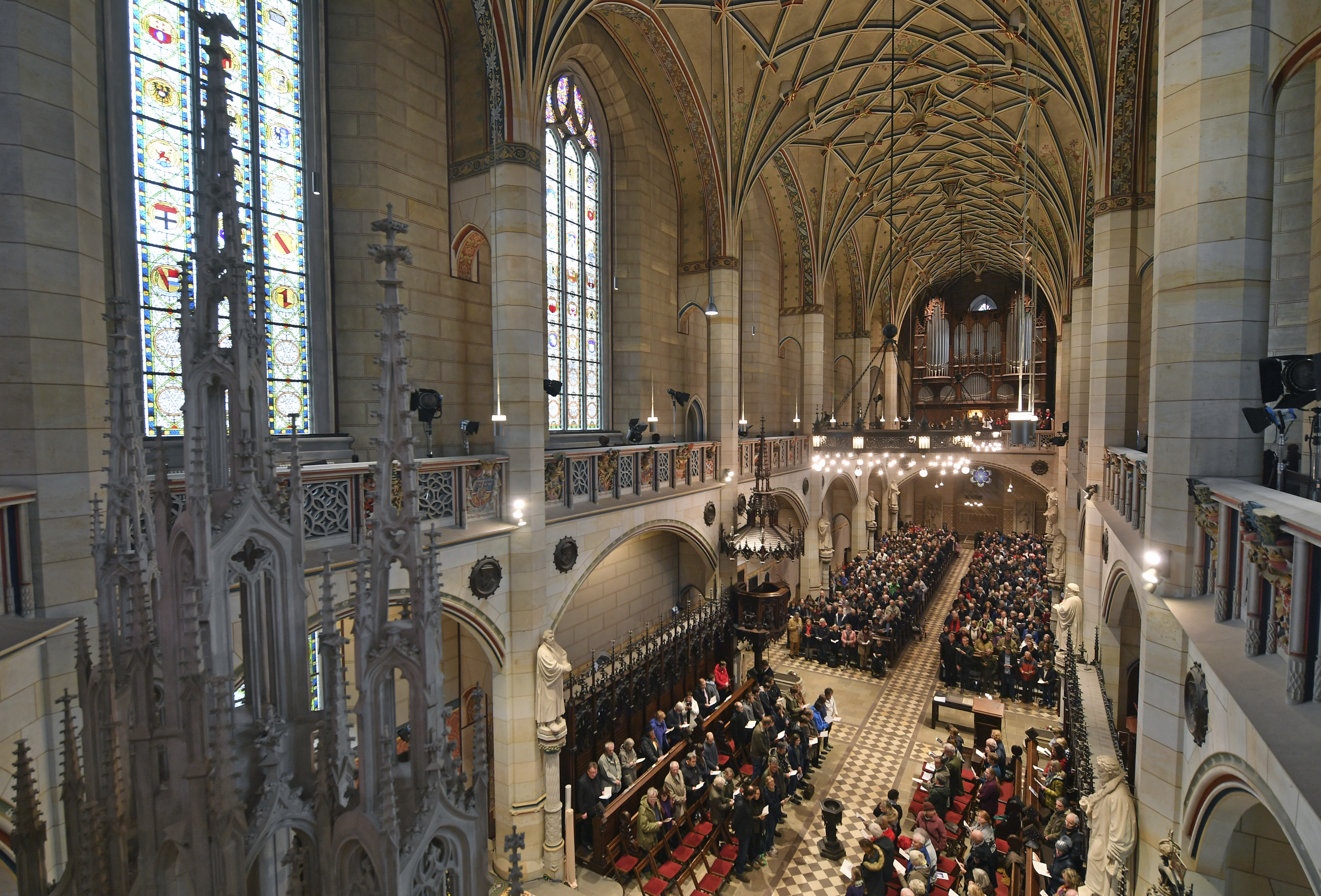 Visitors of the service sit in the All Saints' Church or Castle Church  in Wittenberg, Germany, Tuesday Oct. 31,  2017.  German leaders  will mark the 500th anniversary of the day Martin Luther is said to have nailed his theses challenging the Catholic Church's practice of selling indulgences to a church door, a starting point of the Reformation. (Hendrik Schmidt/dpa via AP)