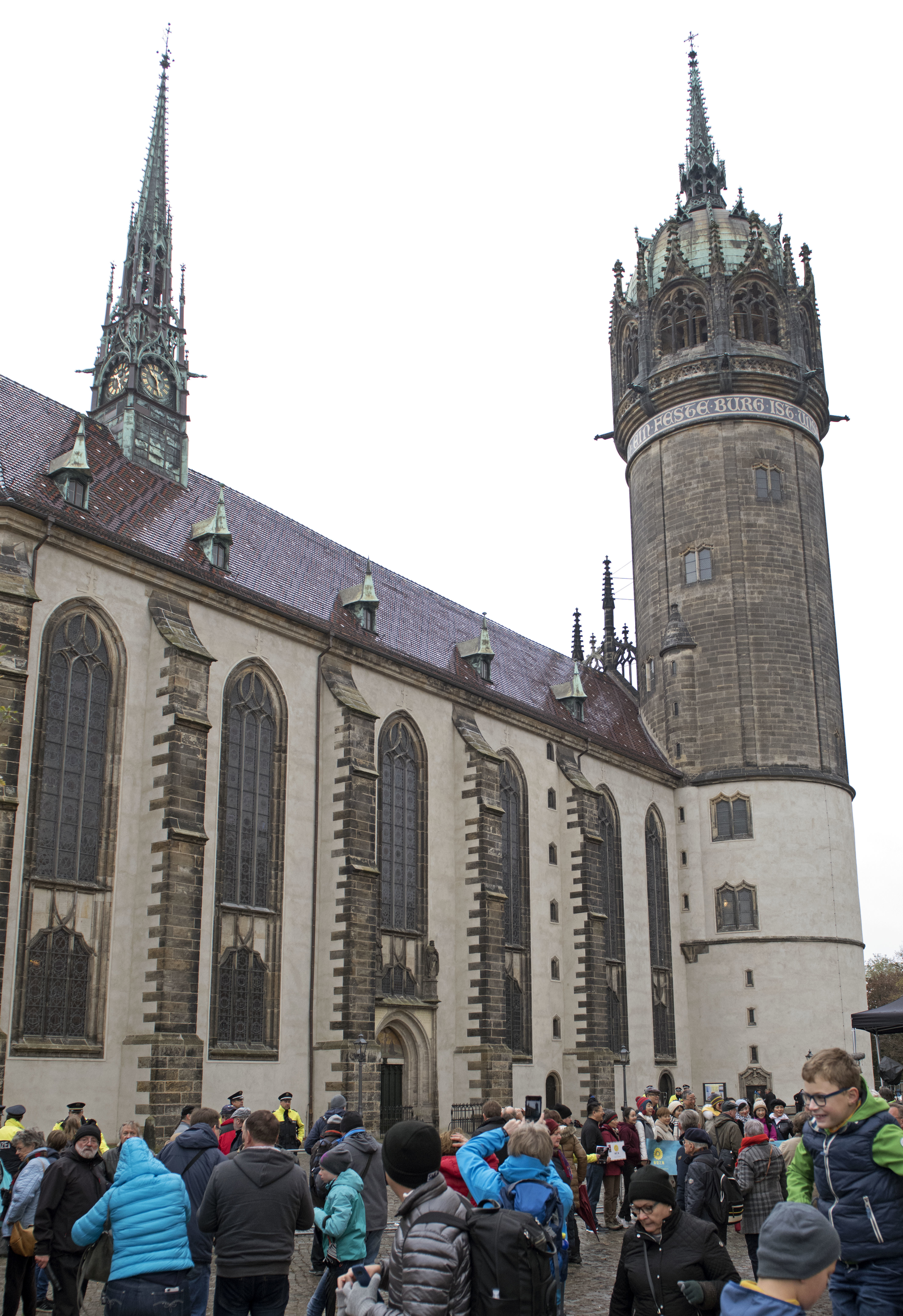 Visitors wait in front of the Castle Church prior the celebrations on the occasion the 500th Anniversary of the Reformation in Wittenberg, Germany, Tuesday, Oct. 31, 2017. German leaders will mark the 500th anniversary of the day Martin Luther is said to have nailed his theses challenging the Catholic Church's practice of selling indulgences to a church door, a starting point of the Reformation.  (AP Photo/Jens Meyer)