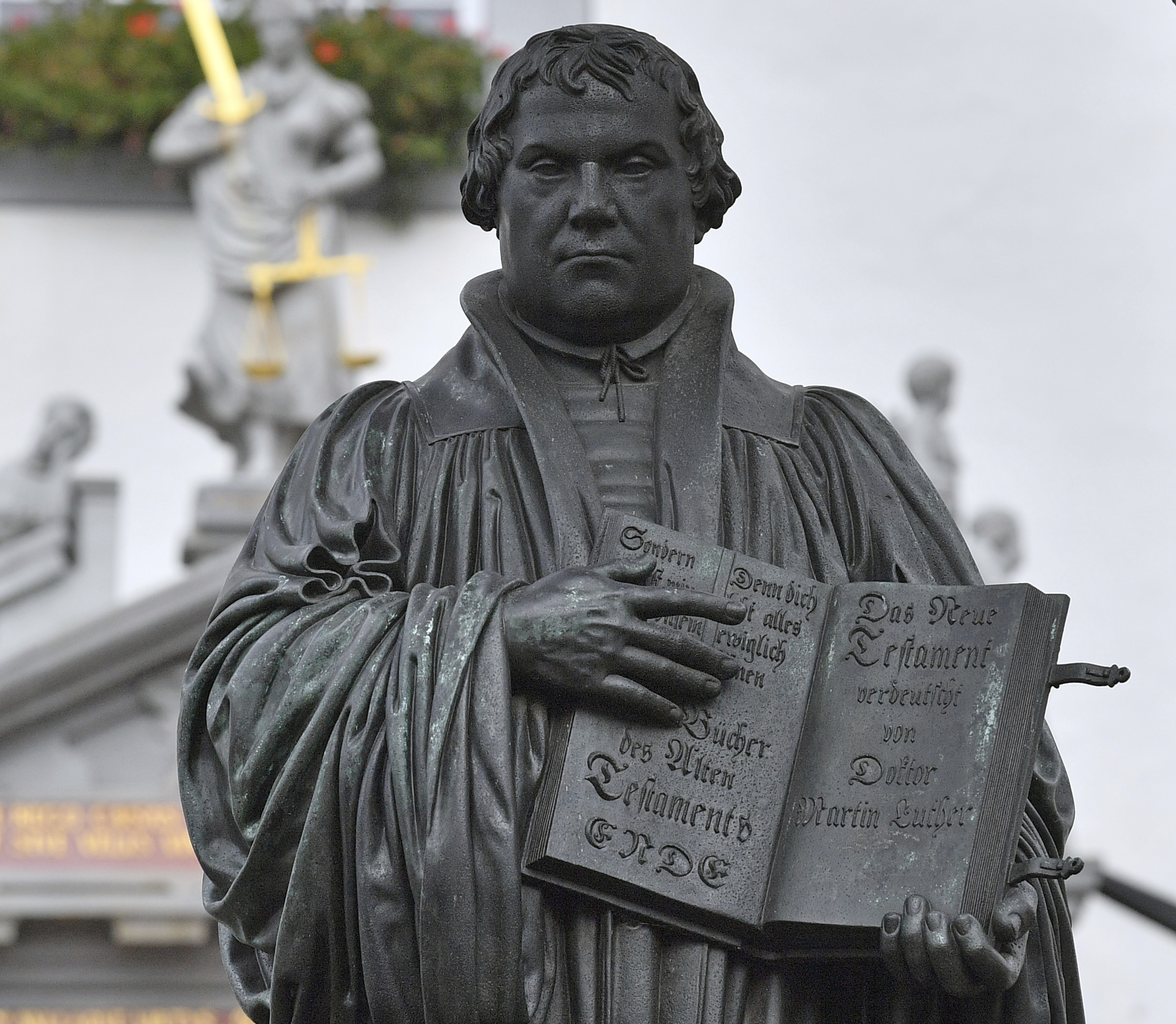 The Martin Luther memorial can be seen on the market square in Wittenberg, Germany, Tuesday, Oct. 31, 2017. German leaders will mark the 500th anniversary of the day Martin Luther is said to have nailed his theses challenging the Catholic Church's practice of selling indulgences to a church door, a starting point of the Reformation.   (Hendrik Schmidt/dpa via AP)