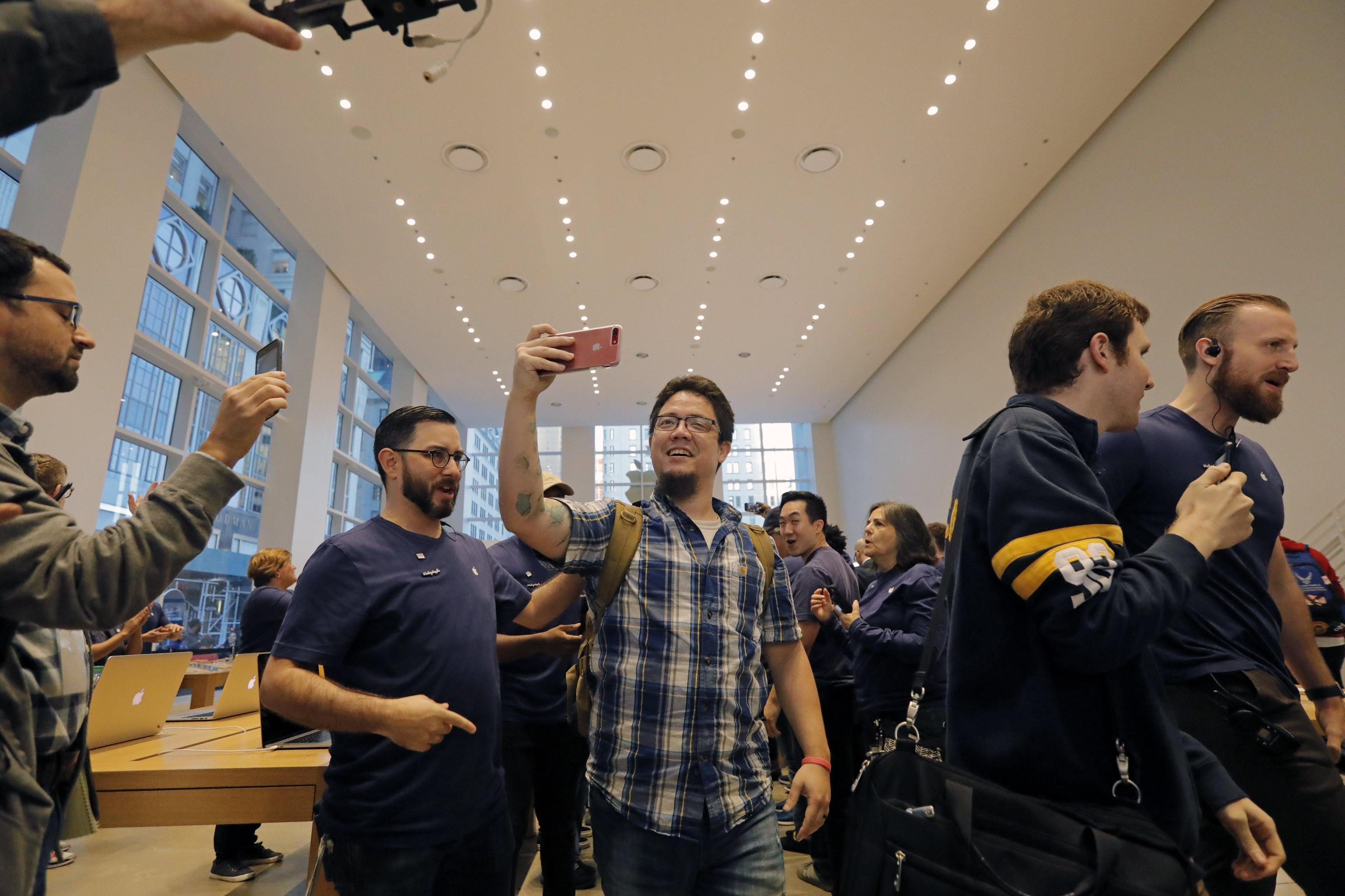 epa06306237 The first customers enter the Apple store on New York's Fifth Avenue to purchase the new Apple iPhone X in New York, New York, USA, 03 November 2017. Apple launched its new iPhone X 03 November marking the 10-year anniversary of the first ever iPhone. Apple's new iPhone X goes on sale in more than 55 countries.  EPA/PETER FOLEY